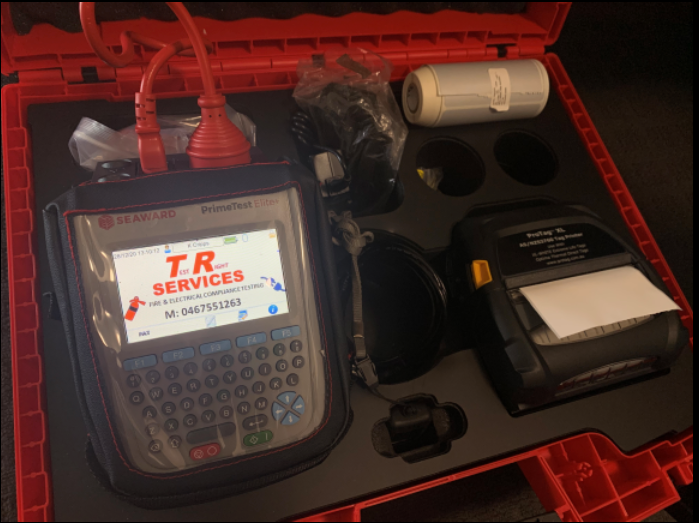 Open red case with device, label printer, and accessories, possibly for technical services.— Test Right Services in Charters Towers, QLD