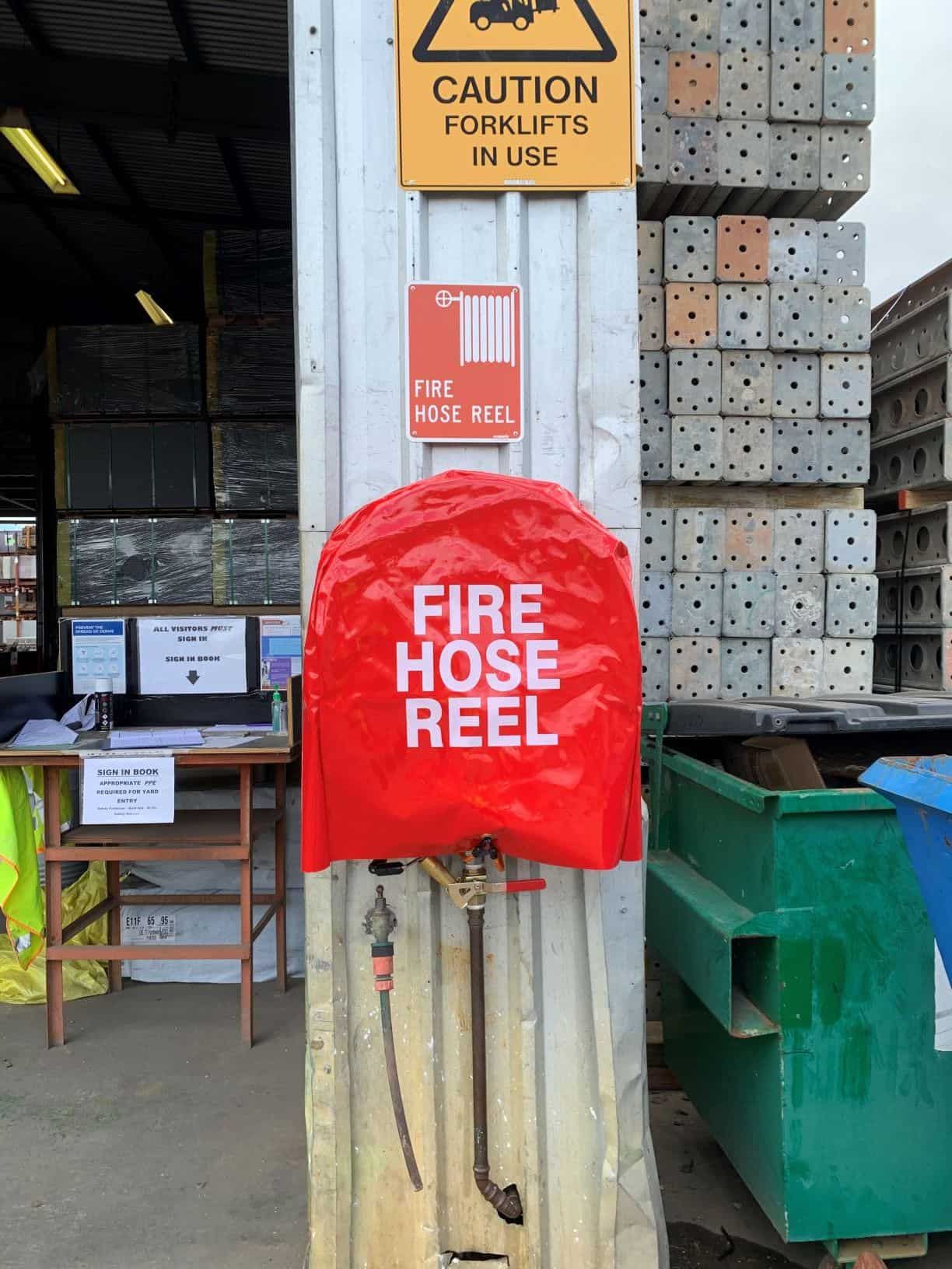 A Red Fire Hose Reel Is Attached to A Wall — Test Right Services in Kirwan, QLD