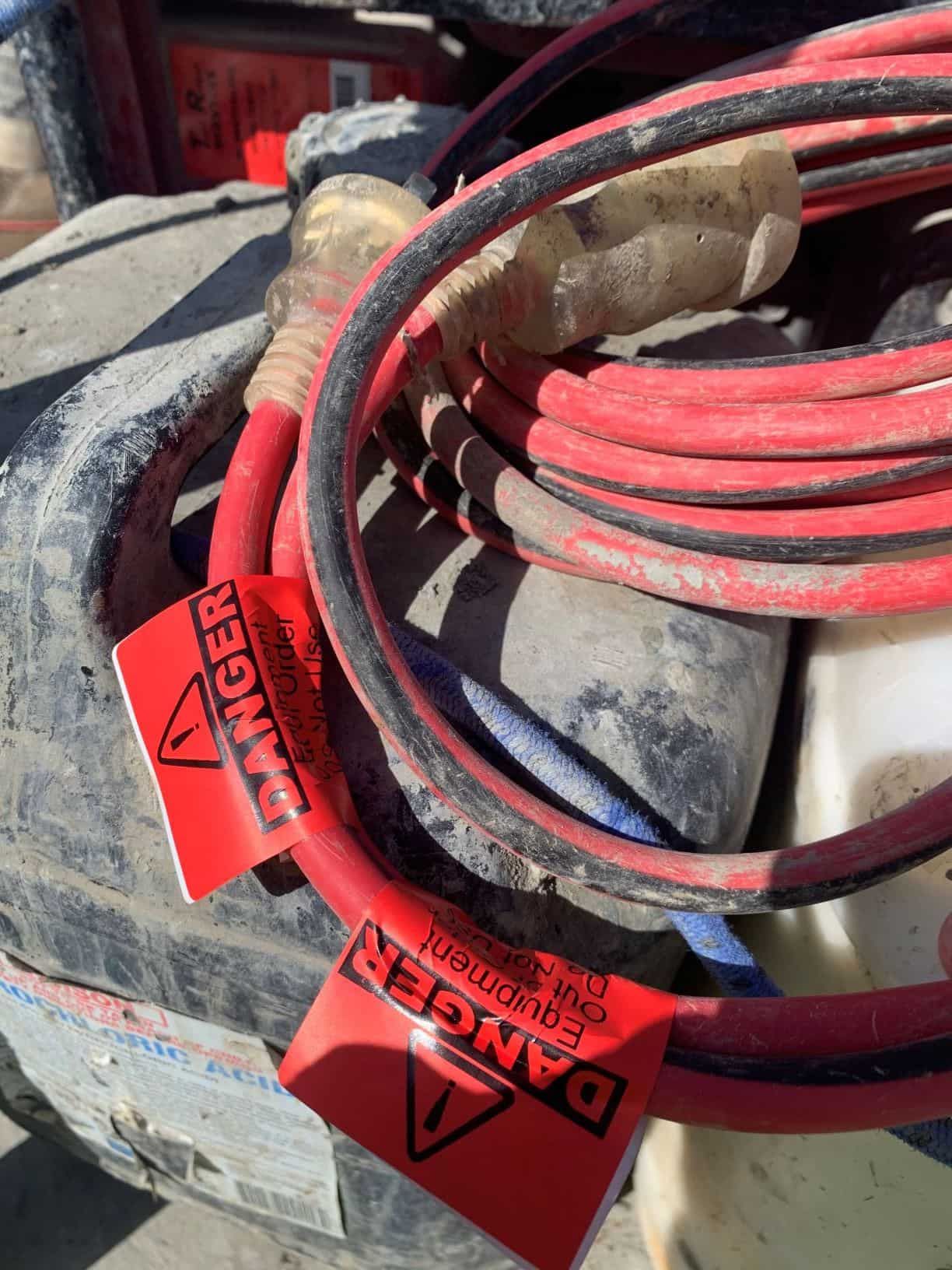 A Red and Black Hose with A Danger Label on It — Test Right Services in Kirwan, QLD
