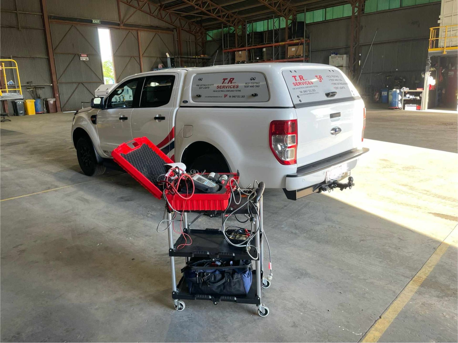 White Ford Ranger with a canopy, parked inside a workshop, with a red diagnostic cart in front.— Test Right Services in Charters Towers, QLD