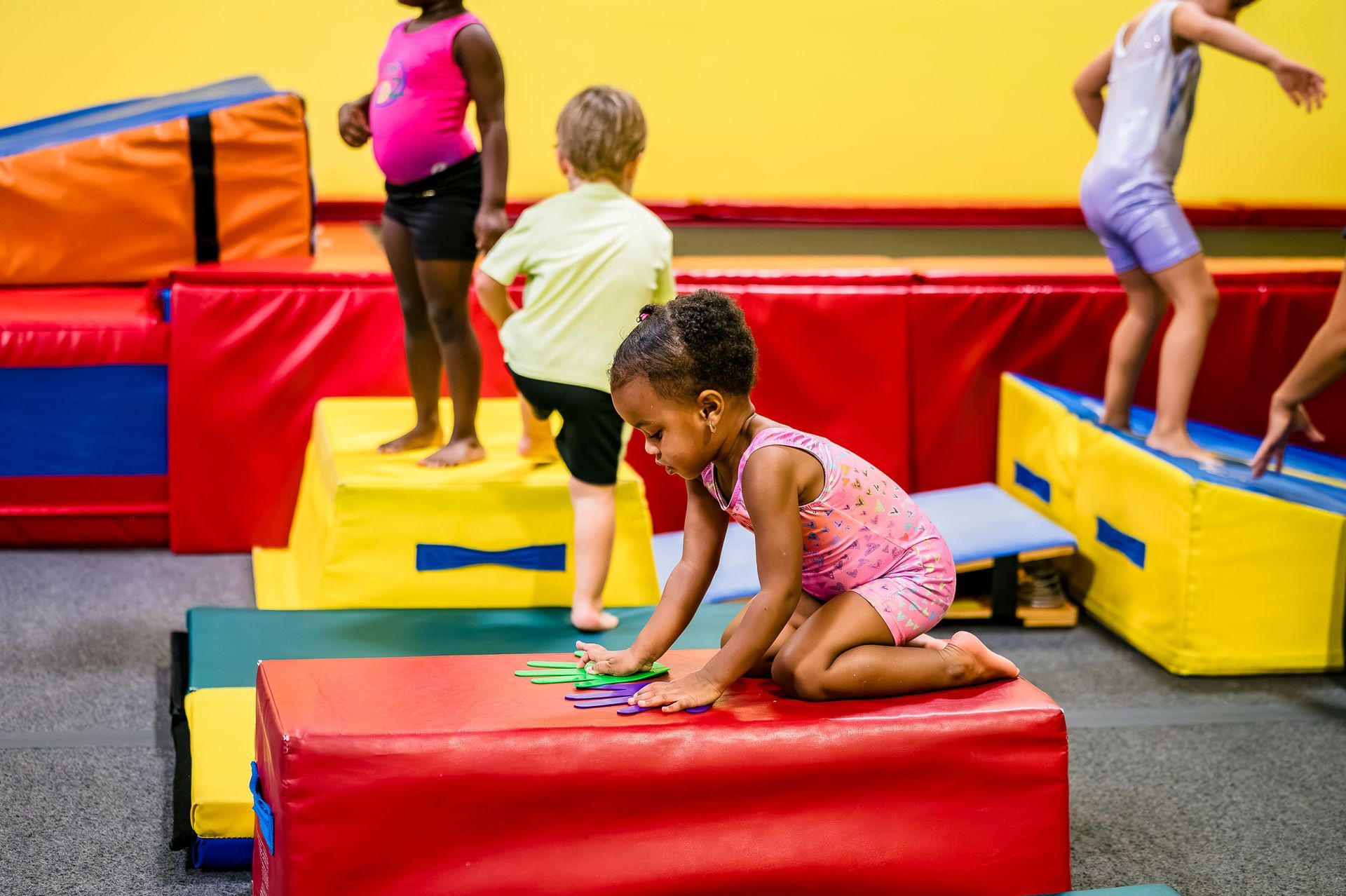 Children playing on colorful indoor inflatable blocks and mats in a play area