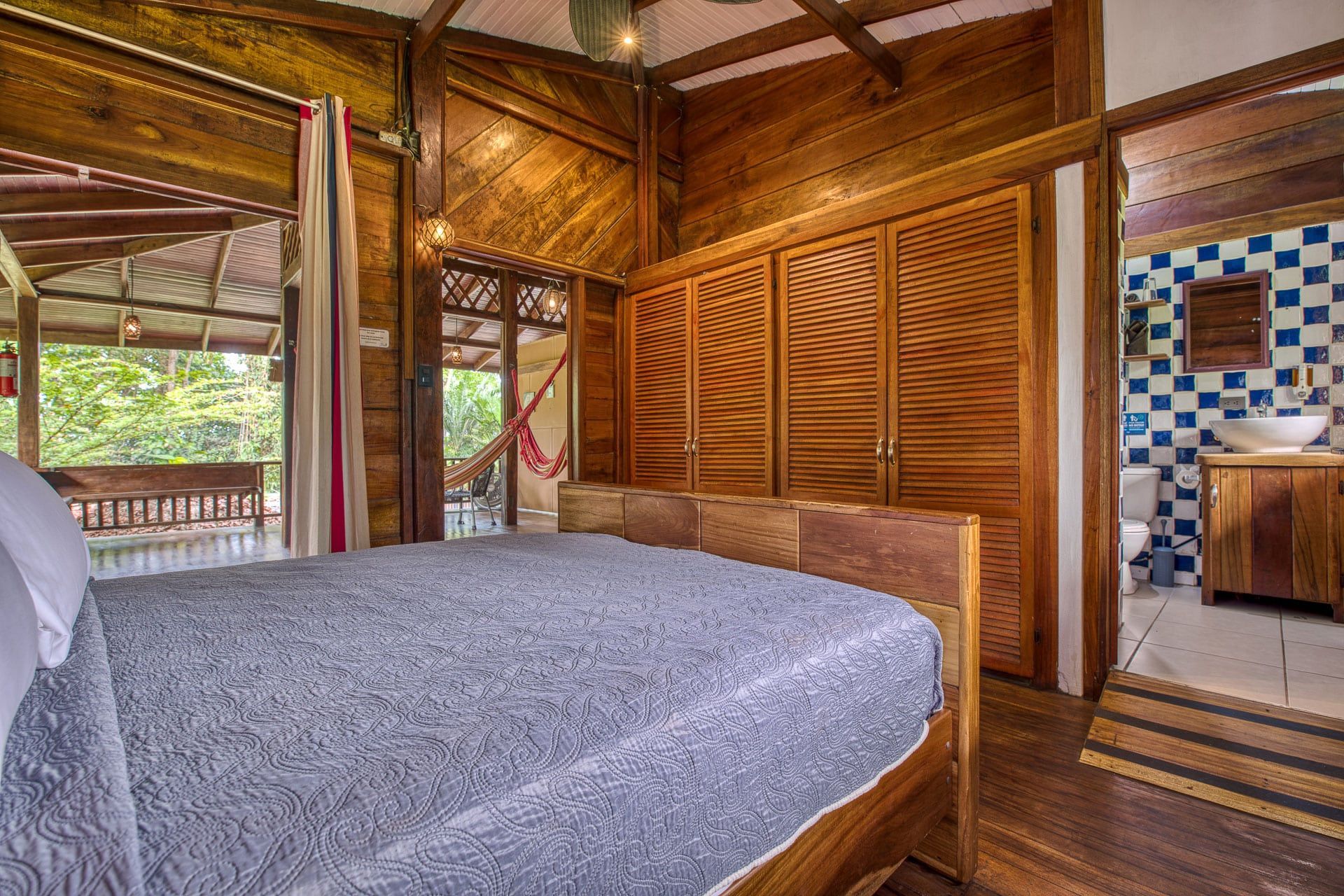A bedroom with a bed and a bathroom in a wooden house.