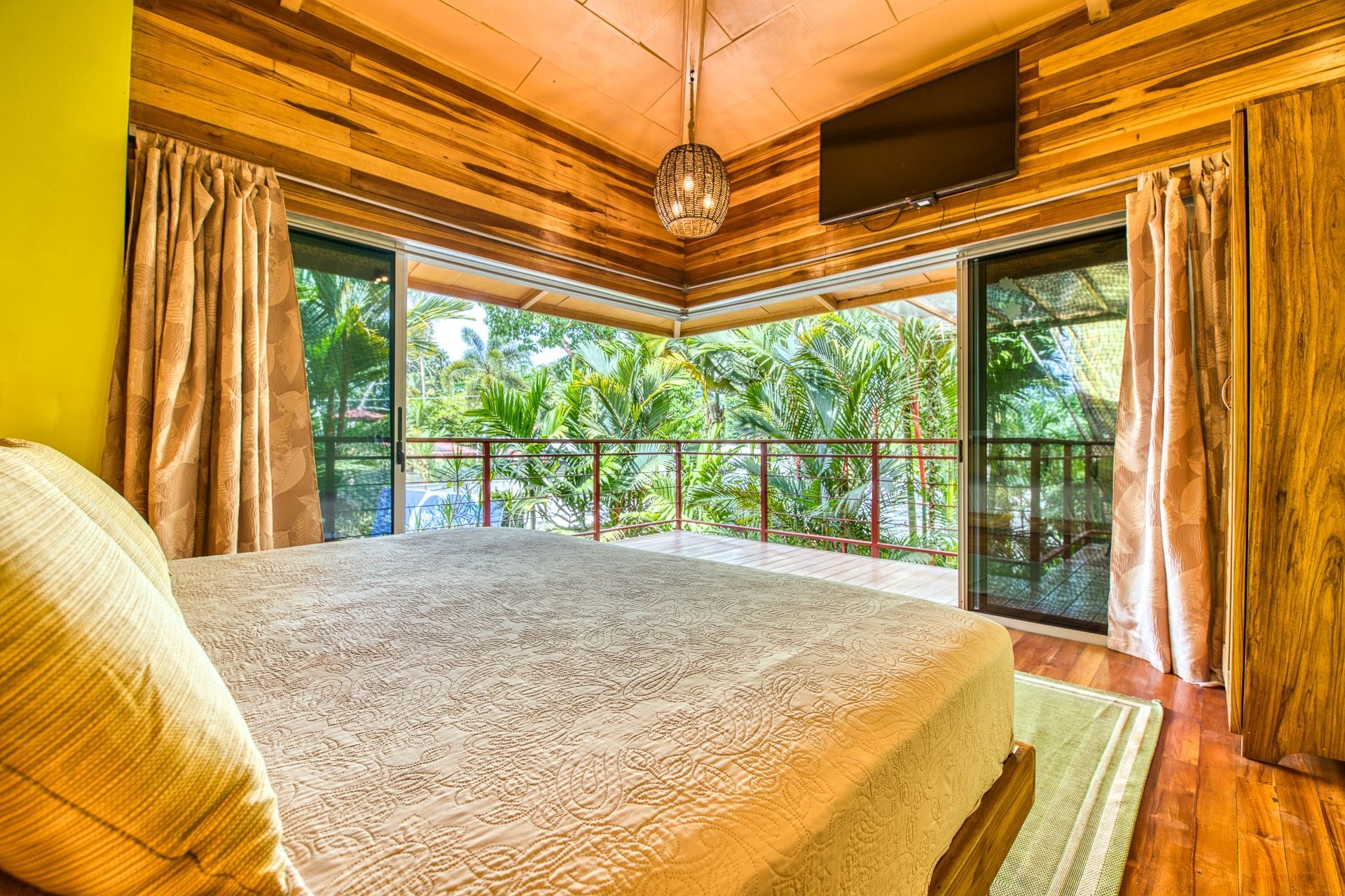 A bedroom with a king size bed and a flat screen tv.