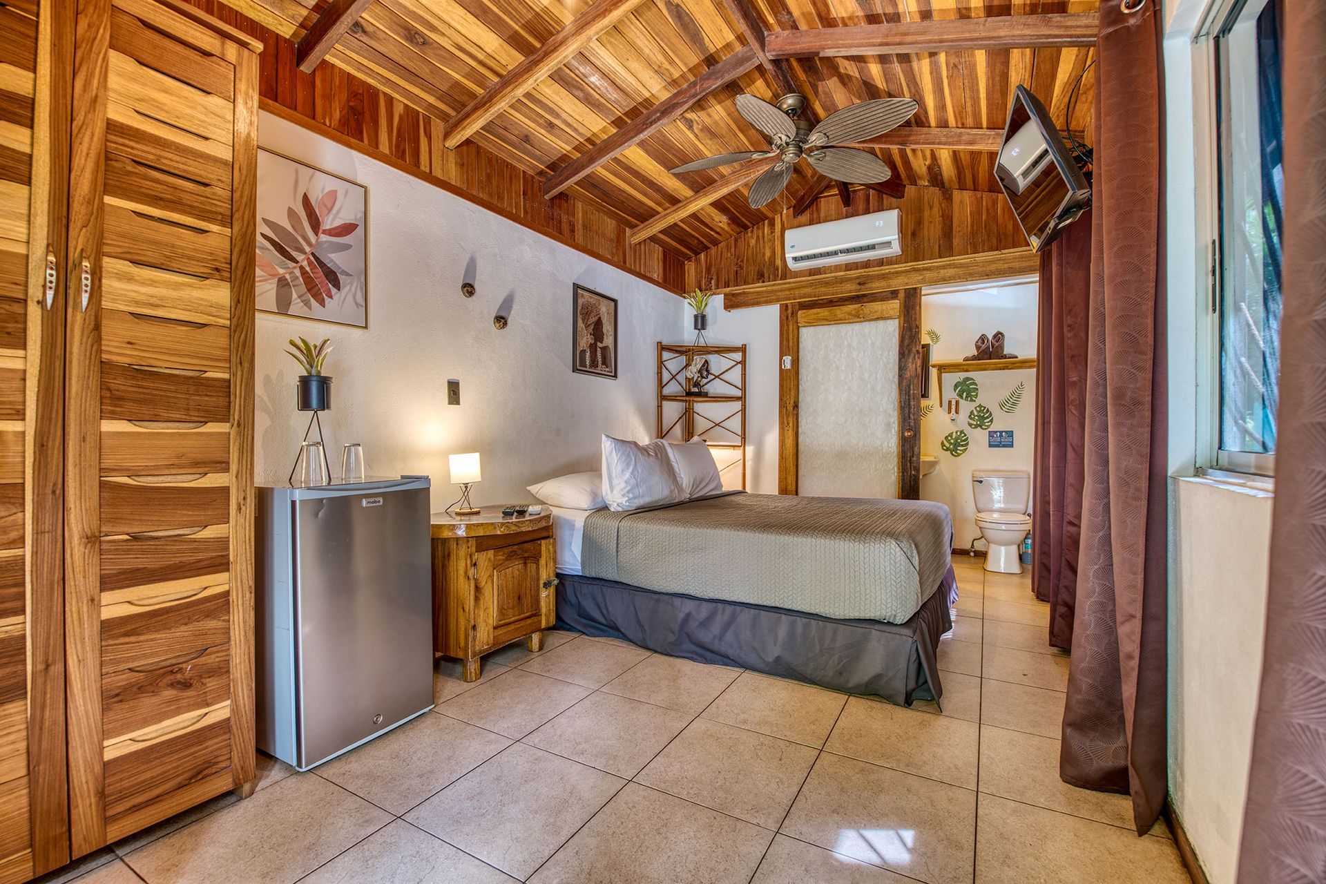 A bedroom with a king size bed and a ceiling fan.