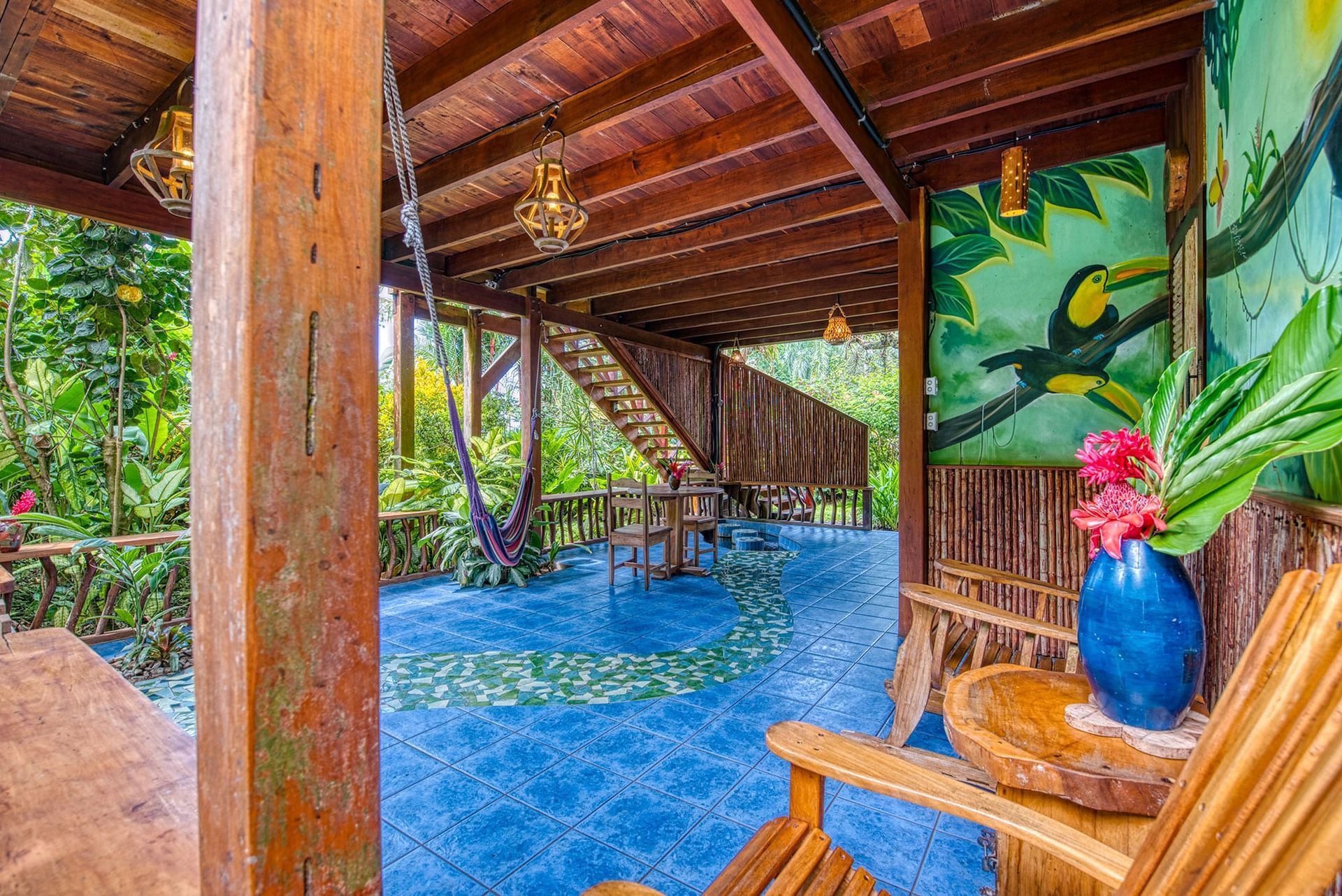 A wooden chair is sitting in a room with a painting of a toucan on the wall.