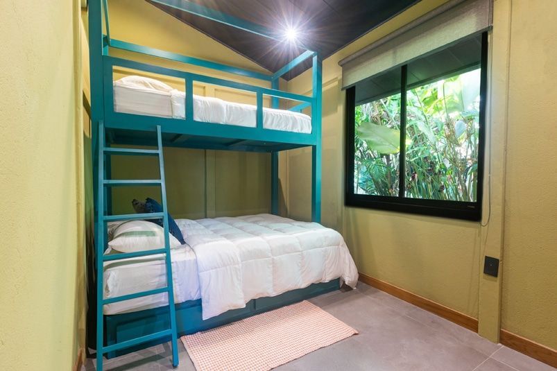 A bedroom with a bunk bed and a window.