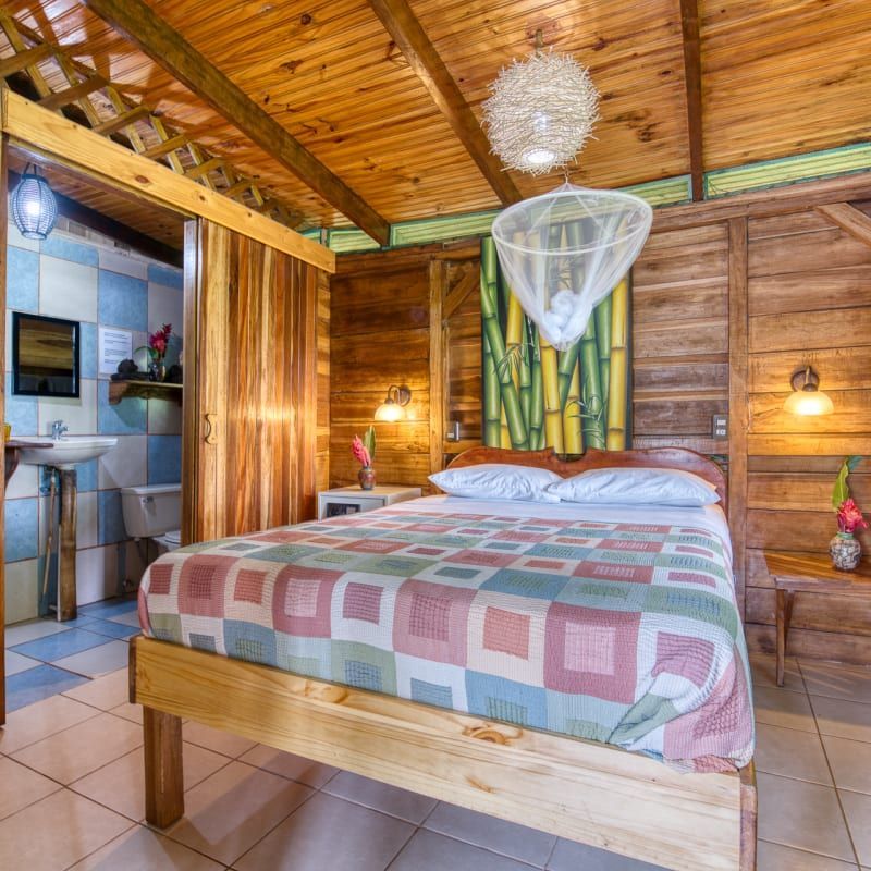 A bedroom with a bed and a mosquito net hanging from the ceiling