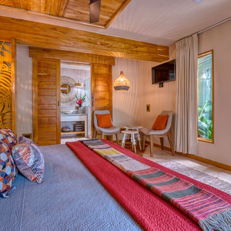 A bedroom with a king size bed and chairs