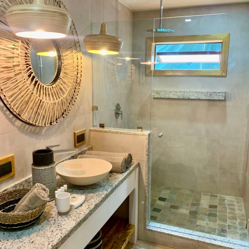 A bathroom with a sink a mirror and a walk in shower