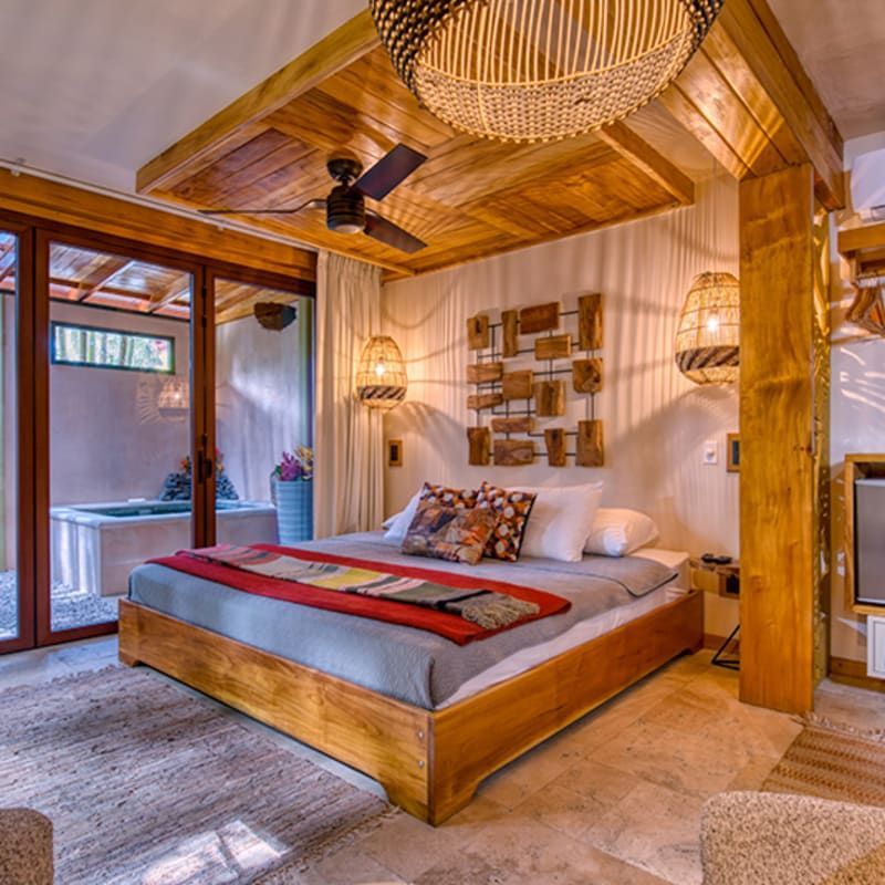 A bedroom with a large bed and a ceiling fan