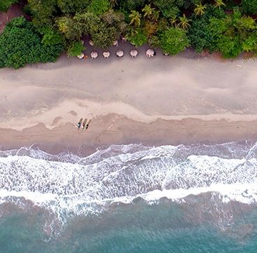 An aerial view of a beach with people walking on it