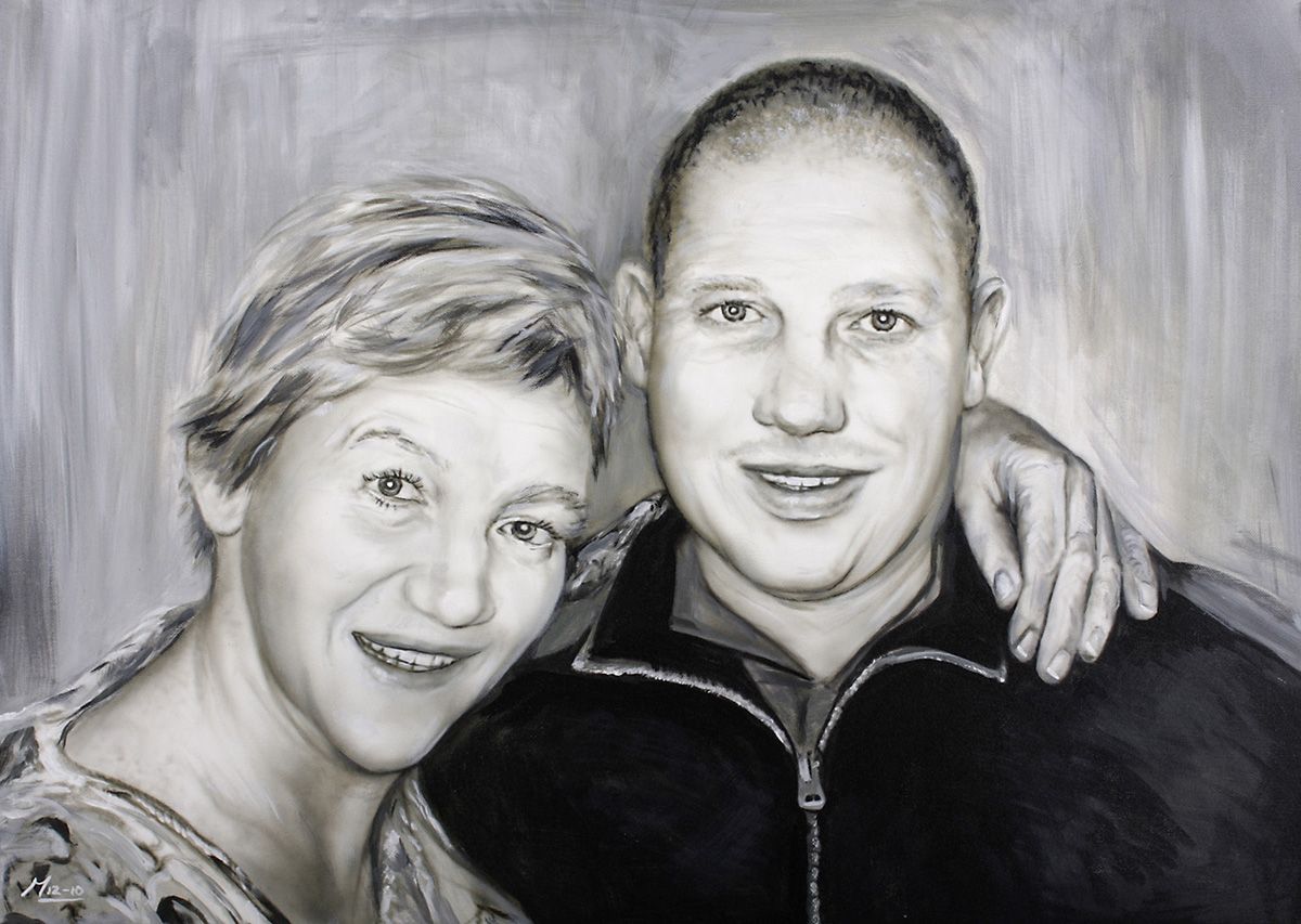 Portret van twee glimlachende en omhelzende mensen. De een heeft kort haar, de ander een kaal hoofd. Zwart-wit.