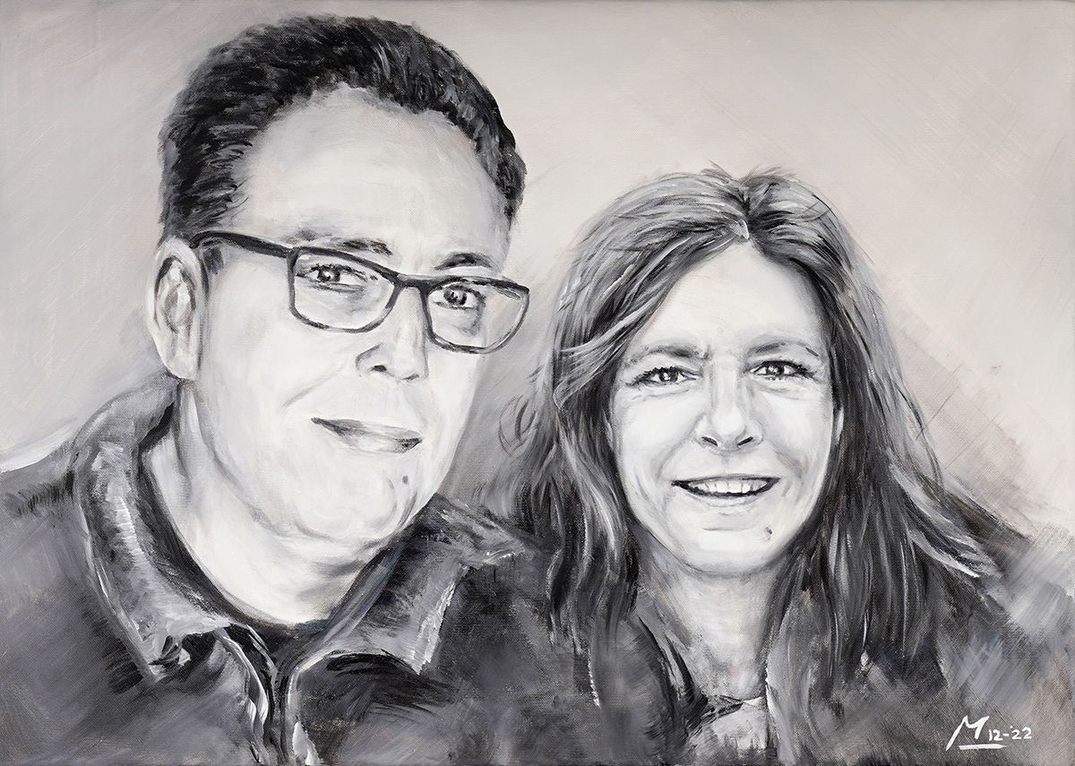 Monochroom portret van een lachend stel: man met bril, vrouw met lang haar.
