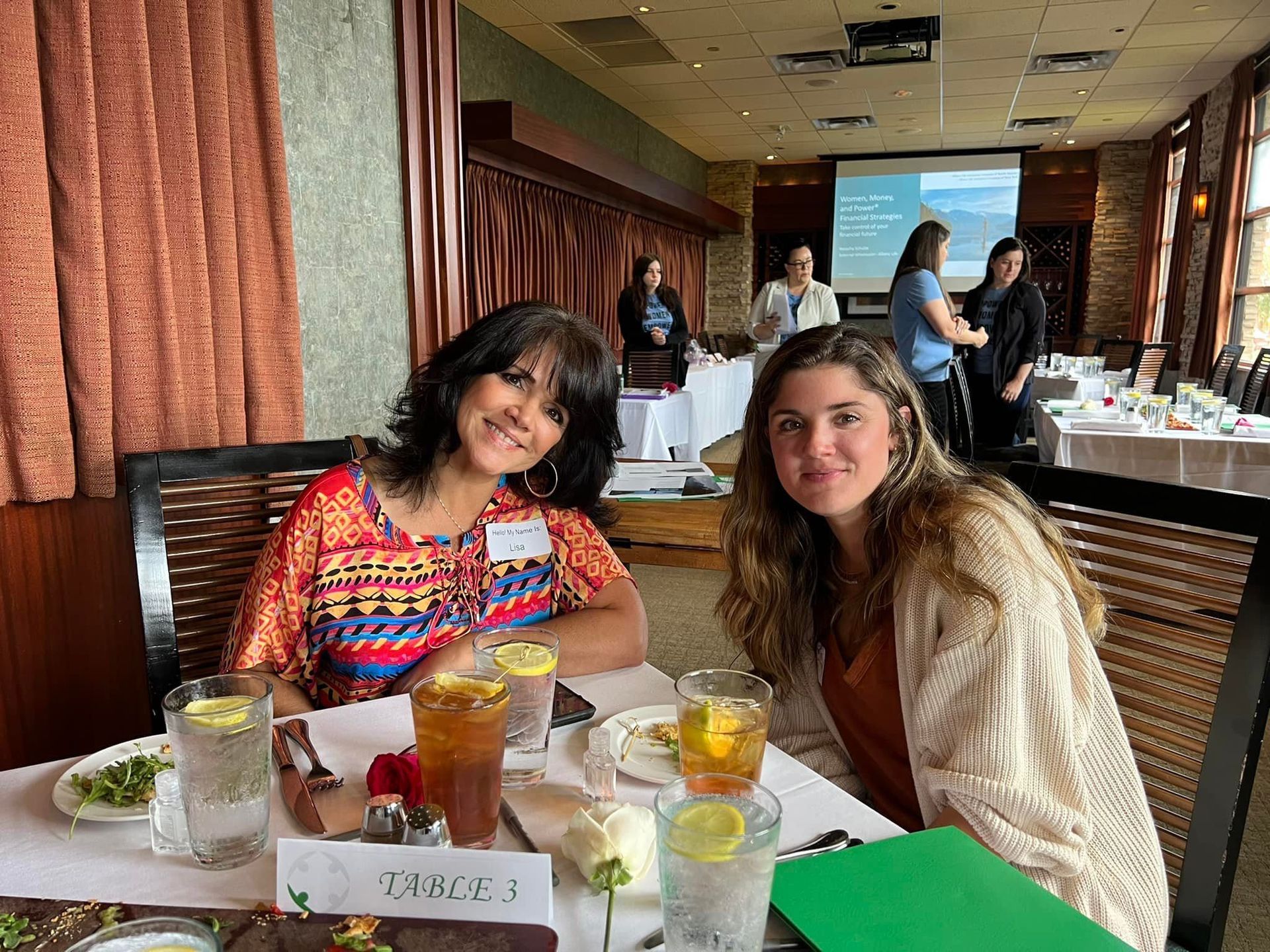 Two women are sitting at a table in a restaurant.