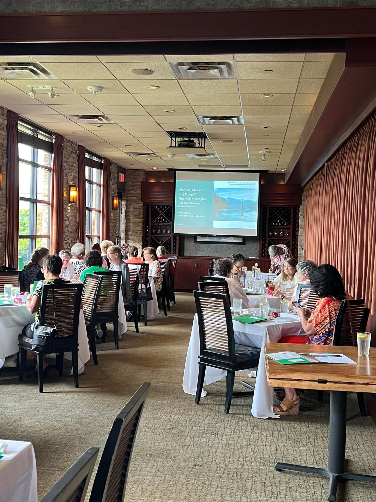 A group of people are sitting at tables in a restaurant.
