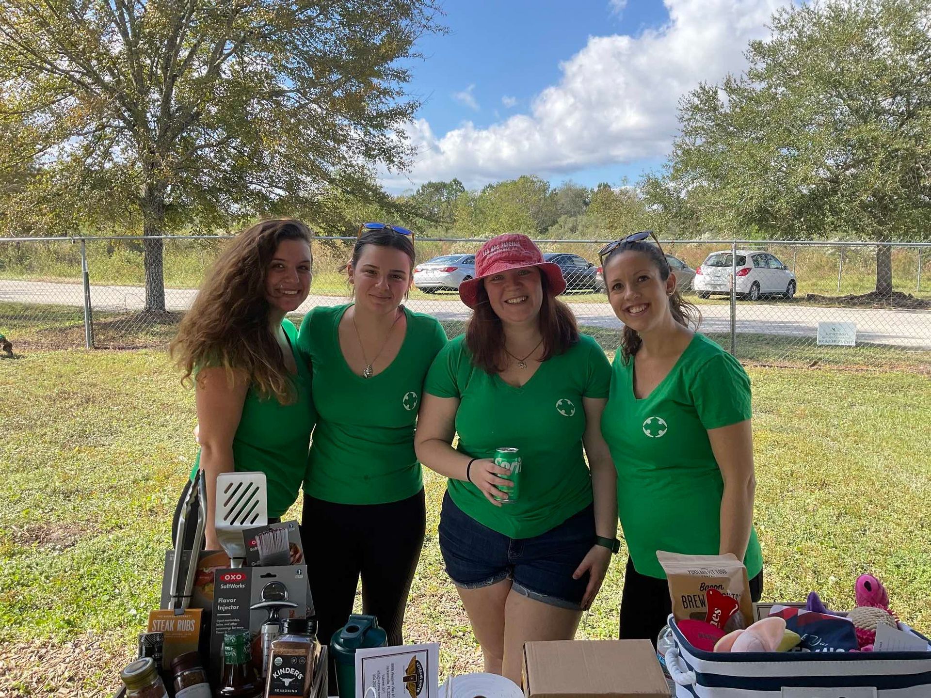 A group of women wearing green shirts are posing for a picture.