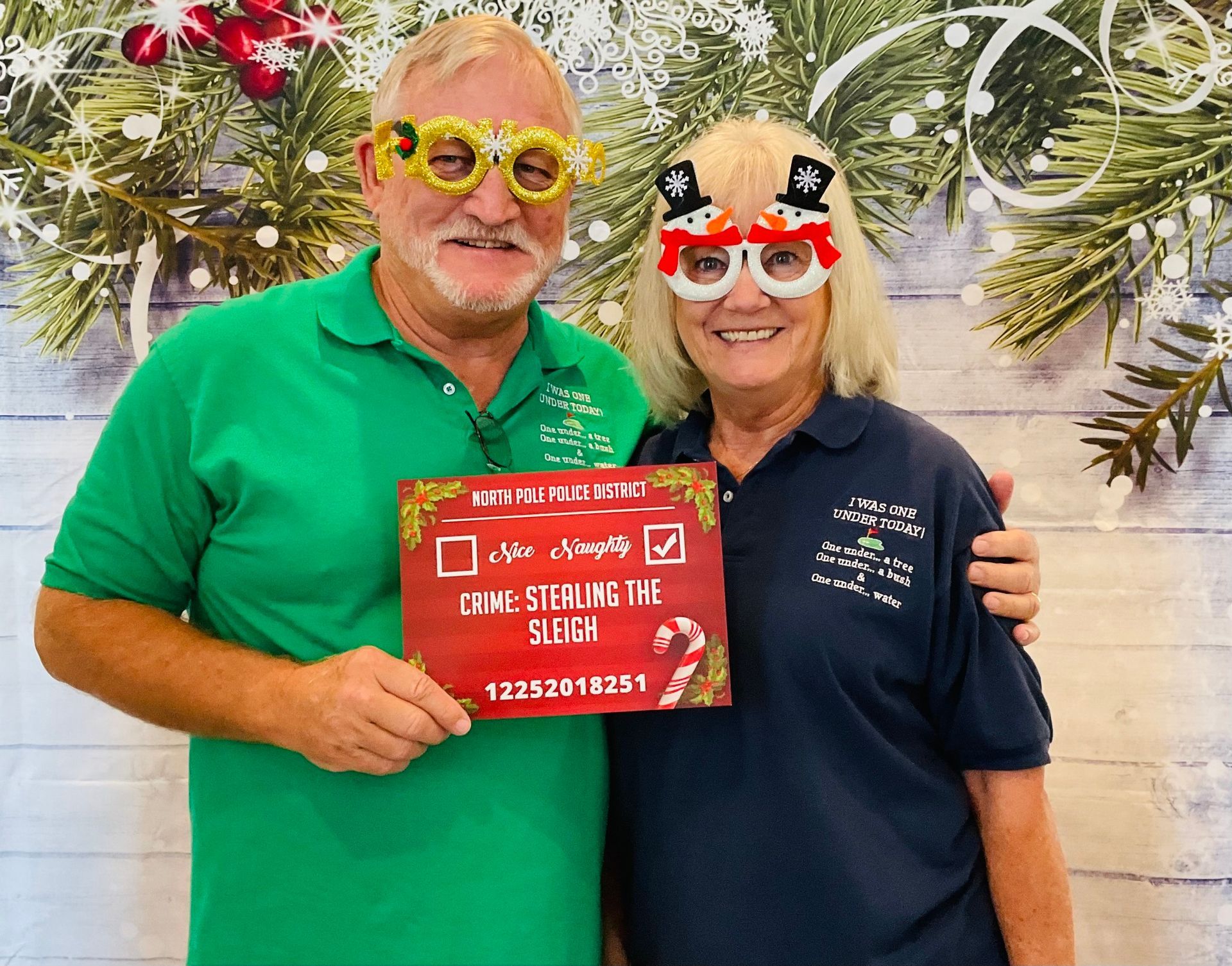 A man and a woman are posing for a picture in front of a christmas background.