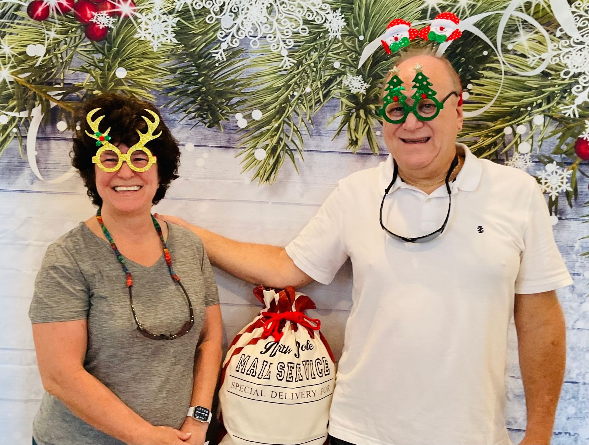 A man and a woman wearing christmas glasses are posing for a picture.