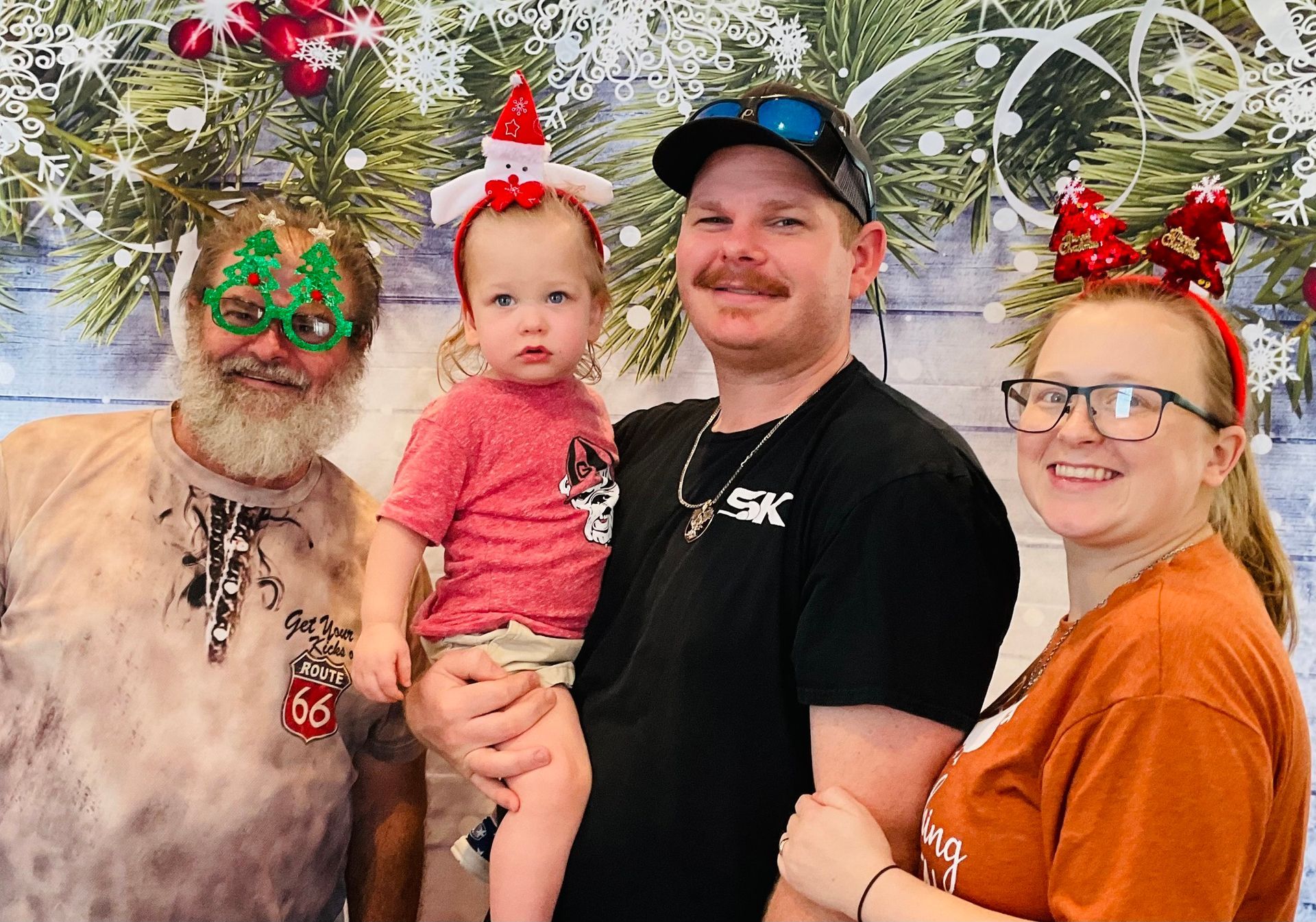 A group of people are posing for a picture in front of a christmas tree.