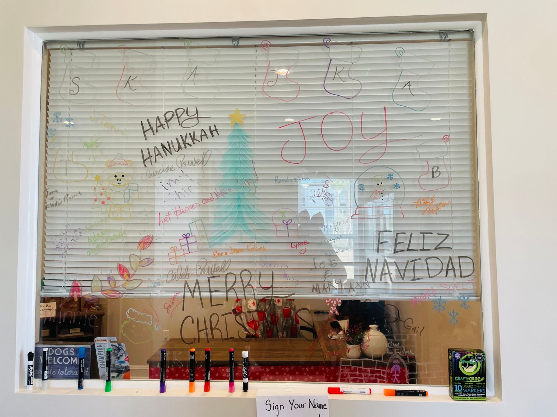 A window with a whiteboard on it that says feliz navidad