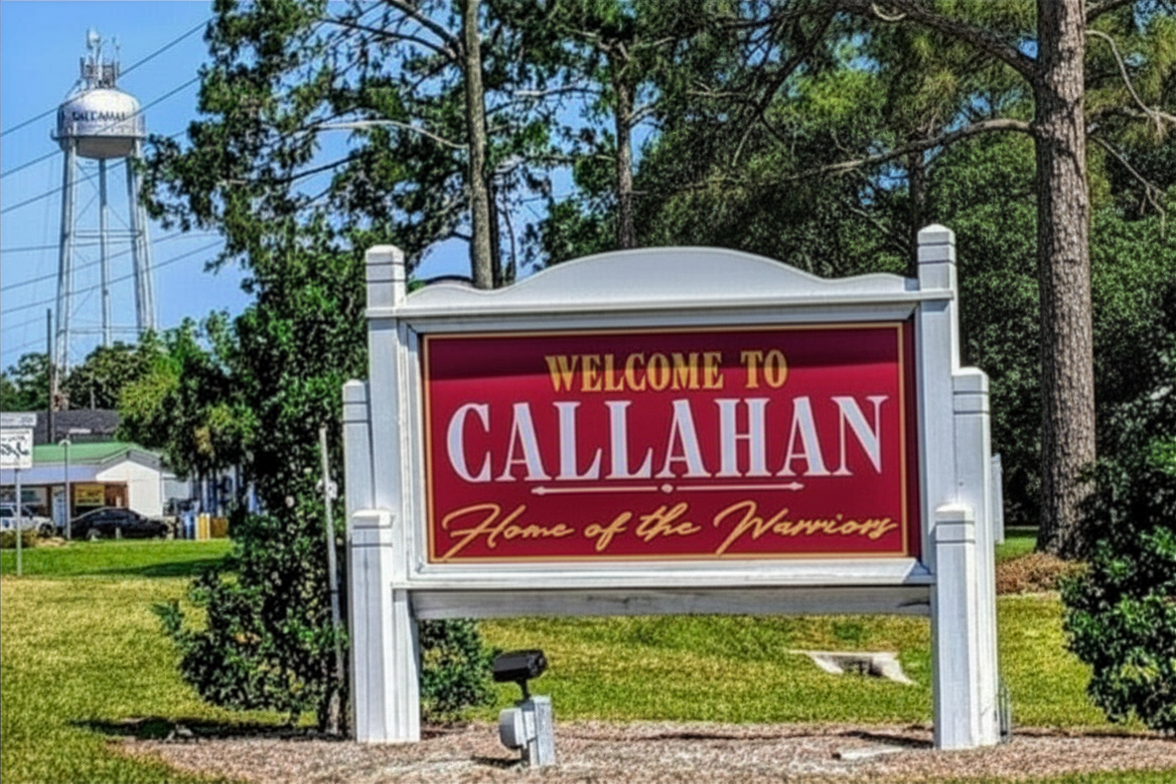Welcome to Callahan town sign in front of trees and a water tower. Callahan, FL