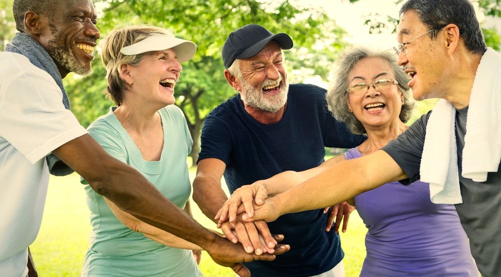 5 Seniors together after a fitness class in the park