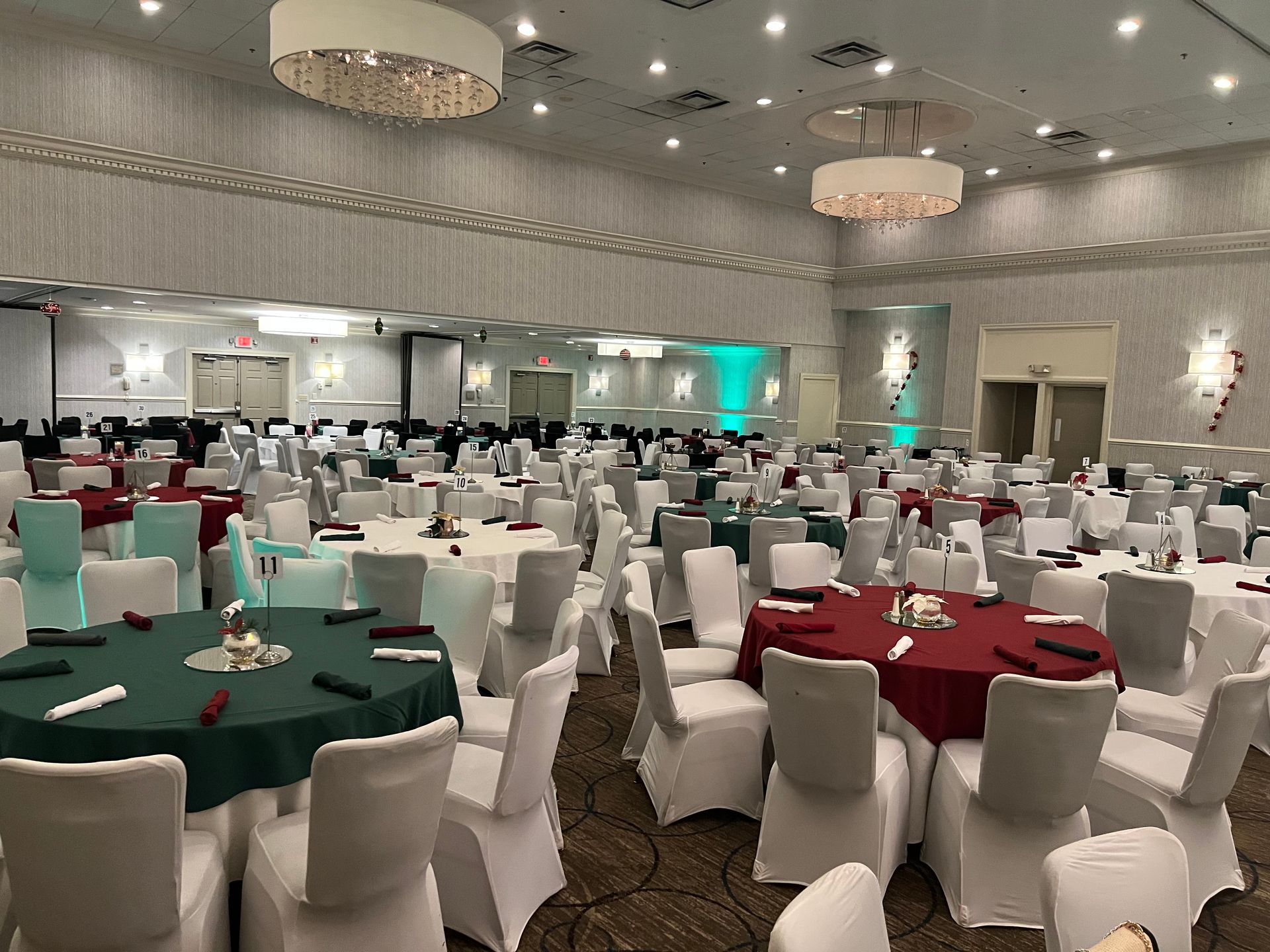 A large room with tables and chairs set up for a wedding reception.