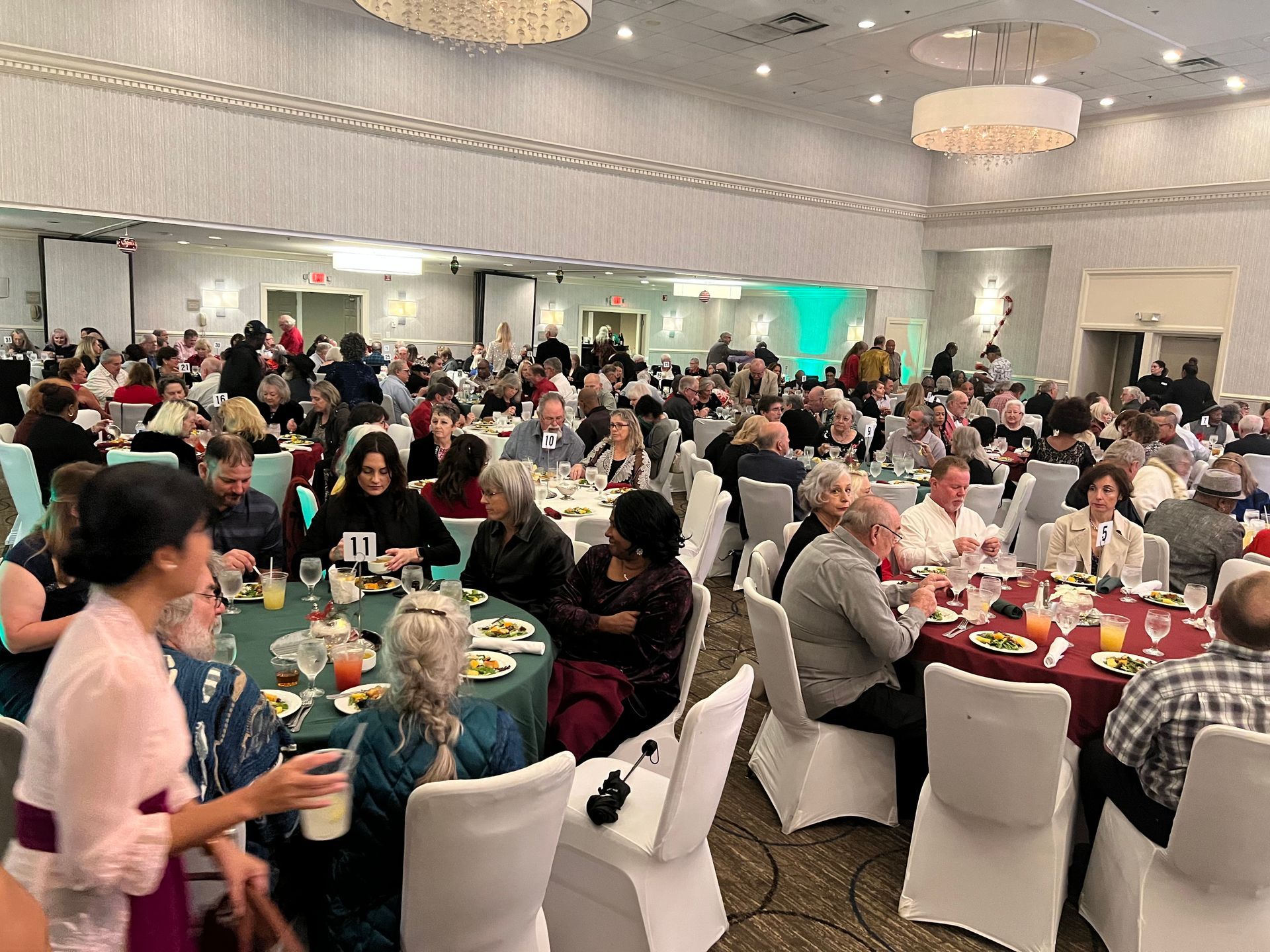 A large group of people are sitting at tables in a large room.