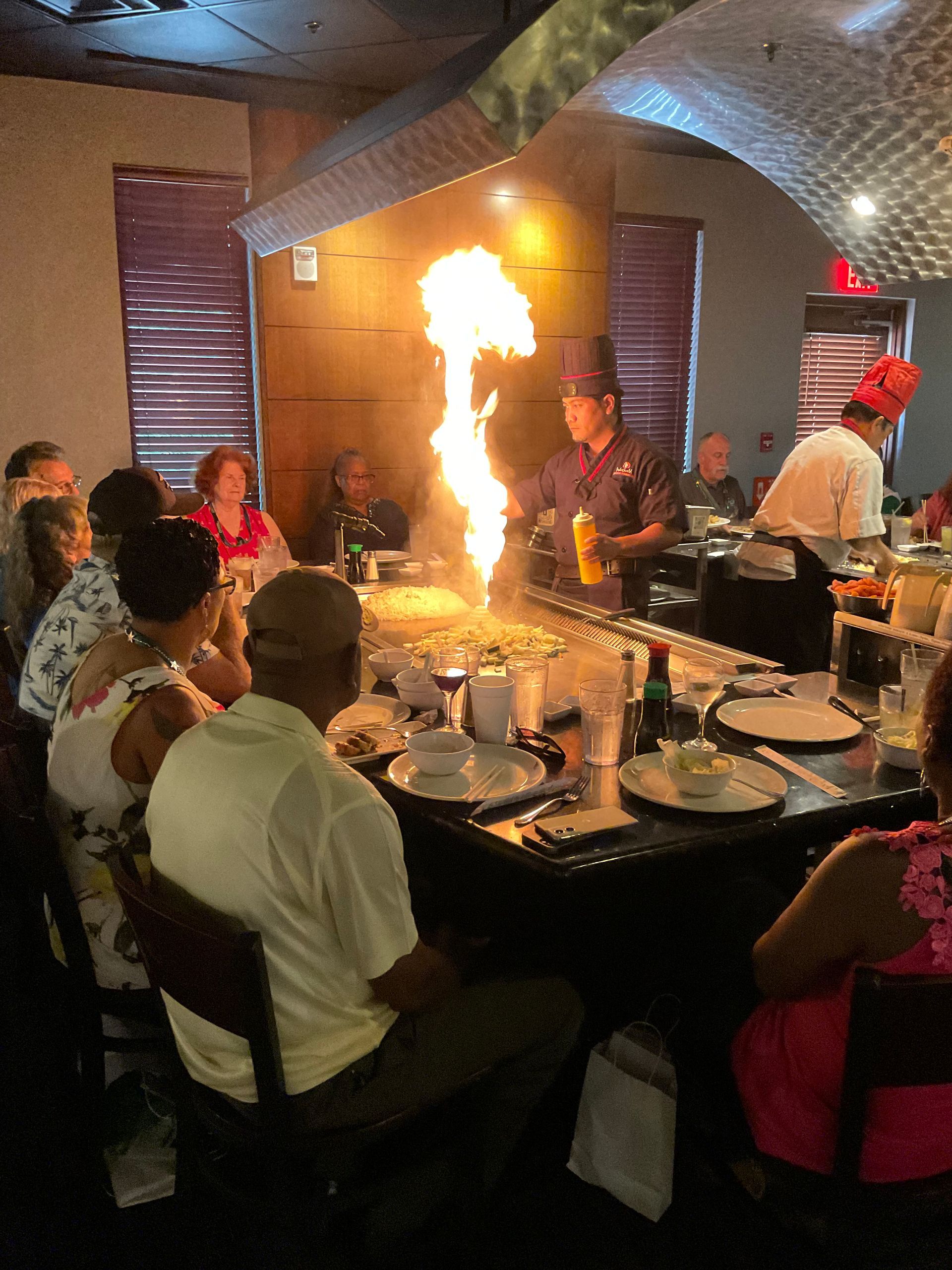Summerlin clients are sitting at a table in a restaurant watching a chef cook