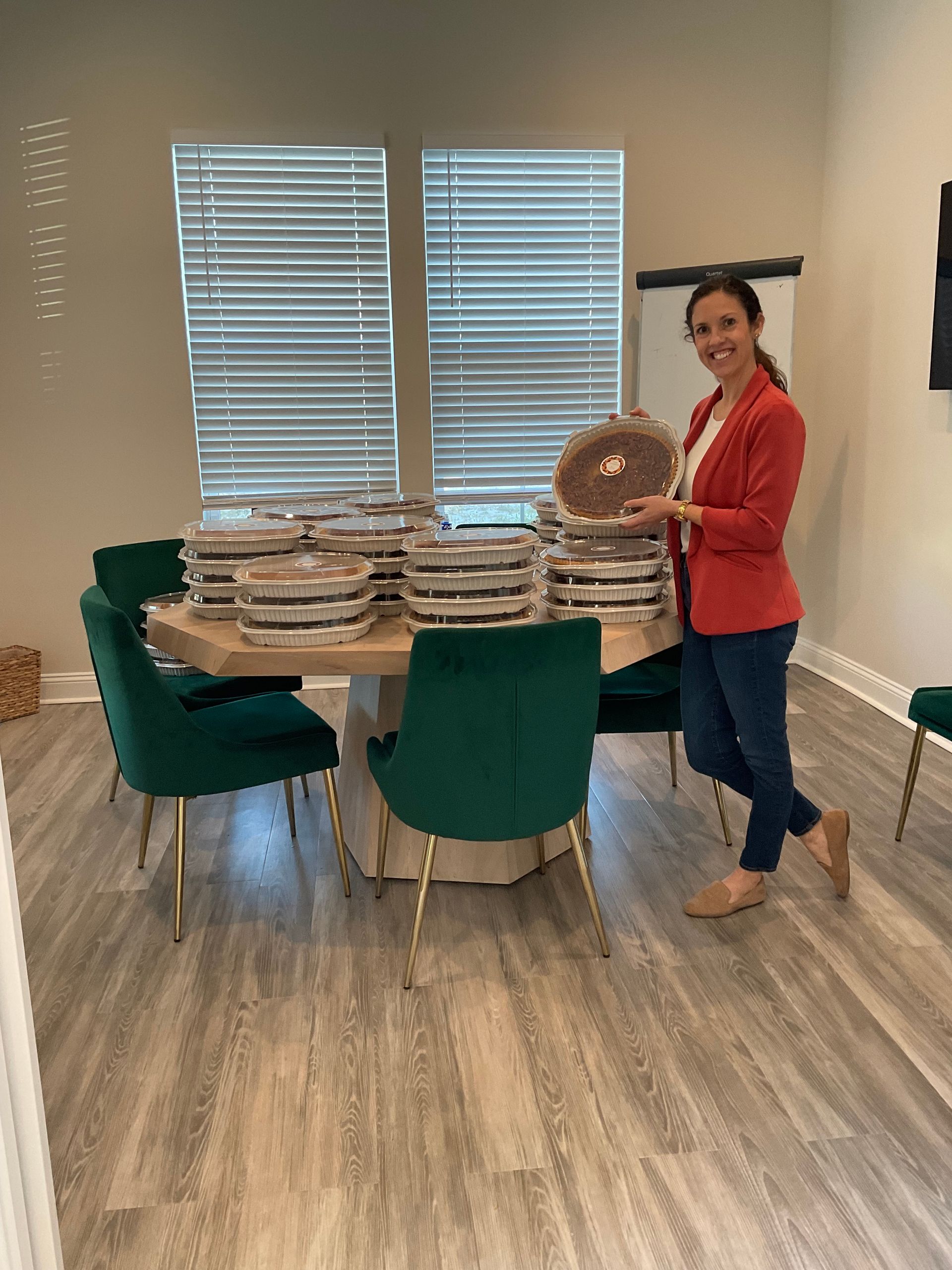 A woman is standing in front of a table with a stack of plates on it.