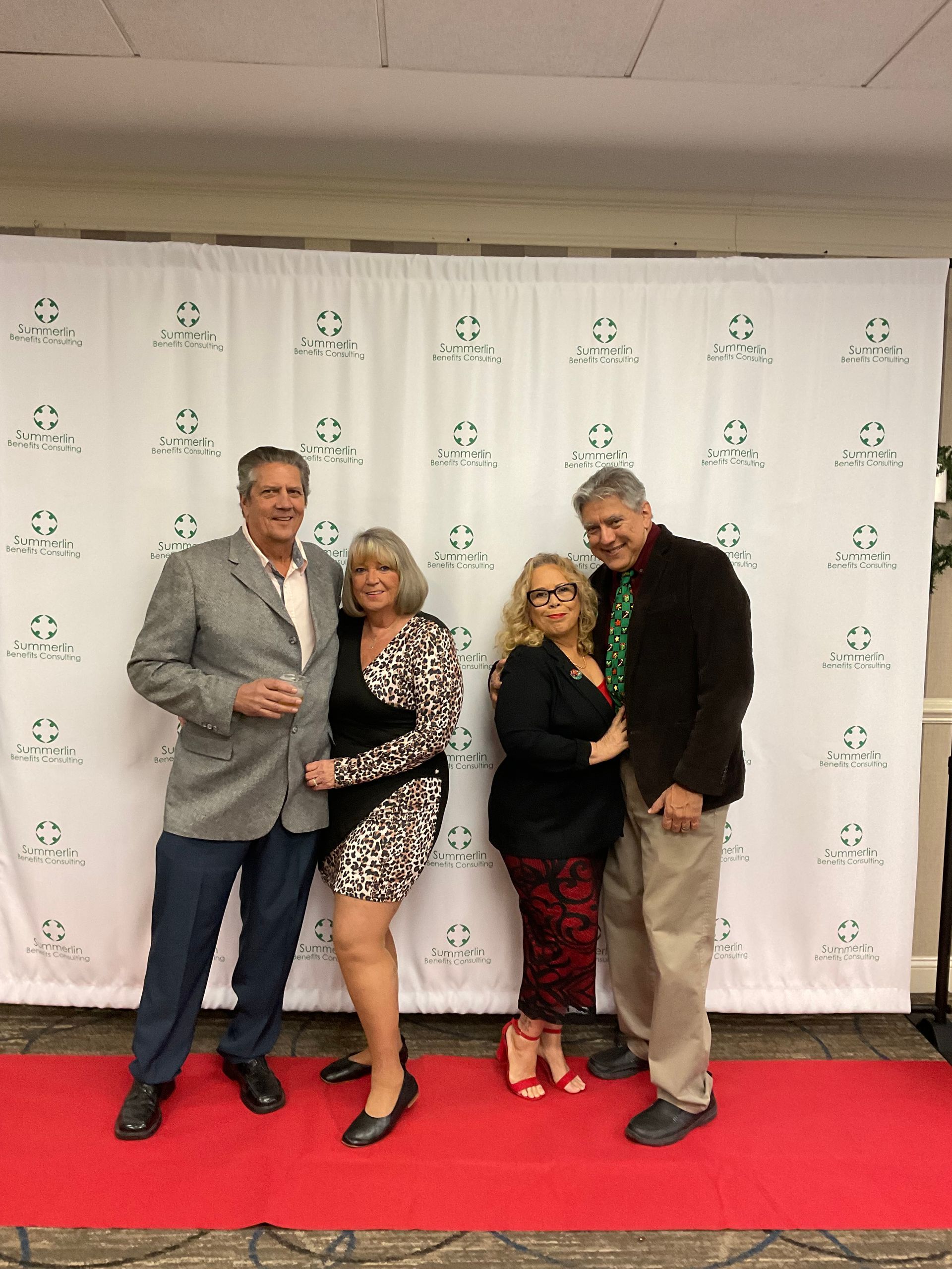 A group of people are posing for a picture on a red carpet.