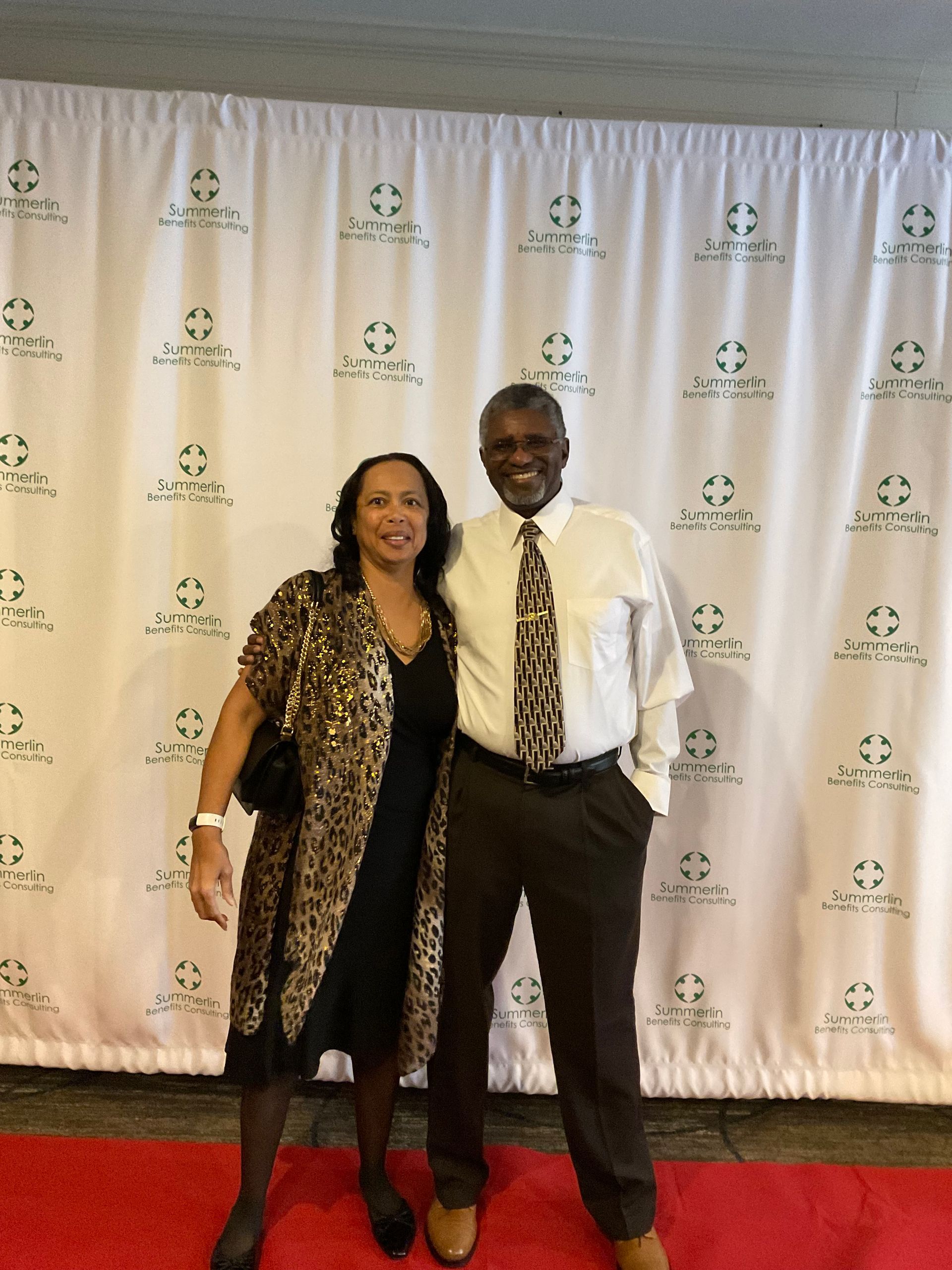 A man and woman pose for a picture on a red carpet