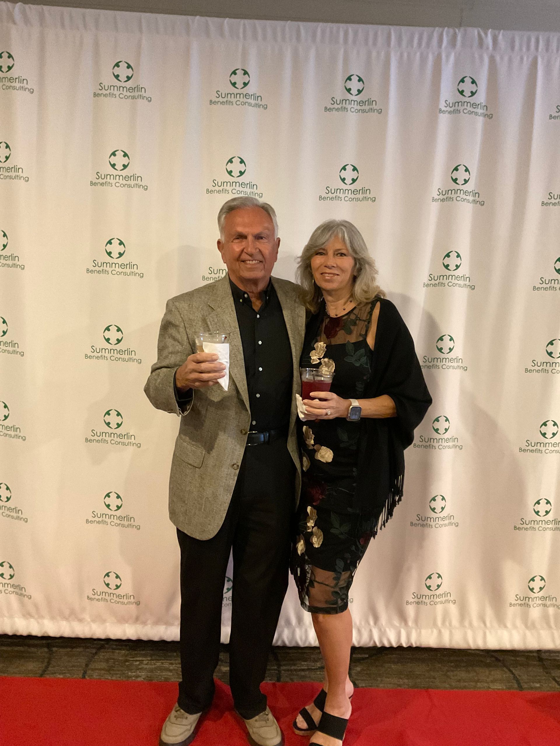 A man and a woman are posing for a picture on a red carpet