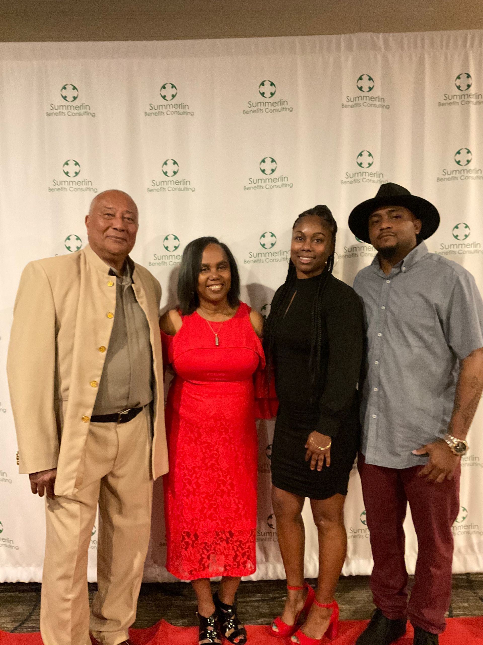 A group of people posing for a picture on a red carpet