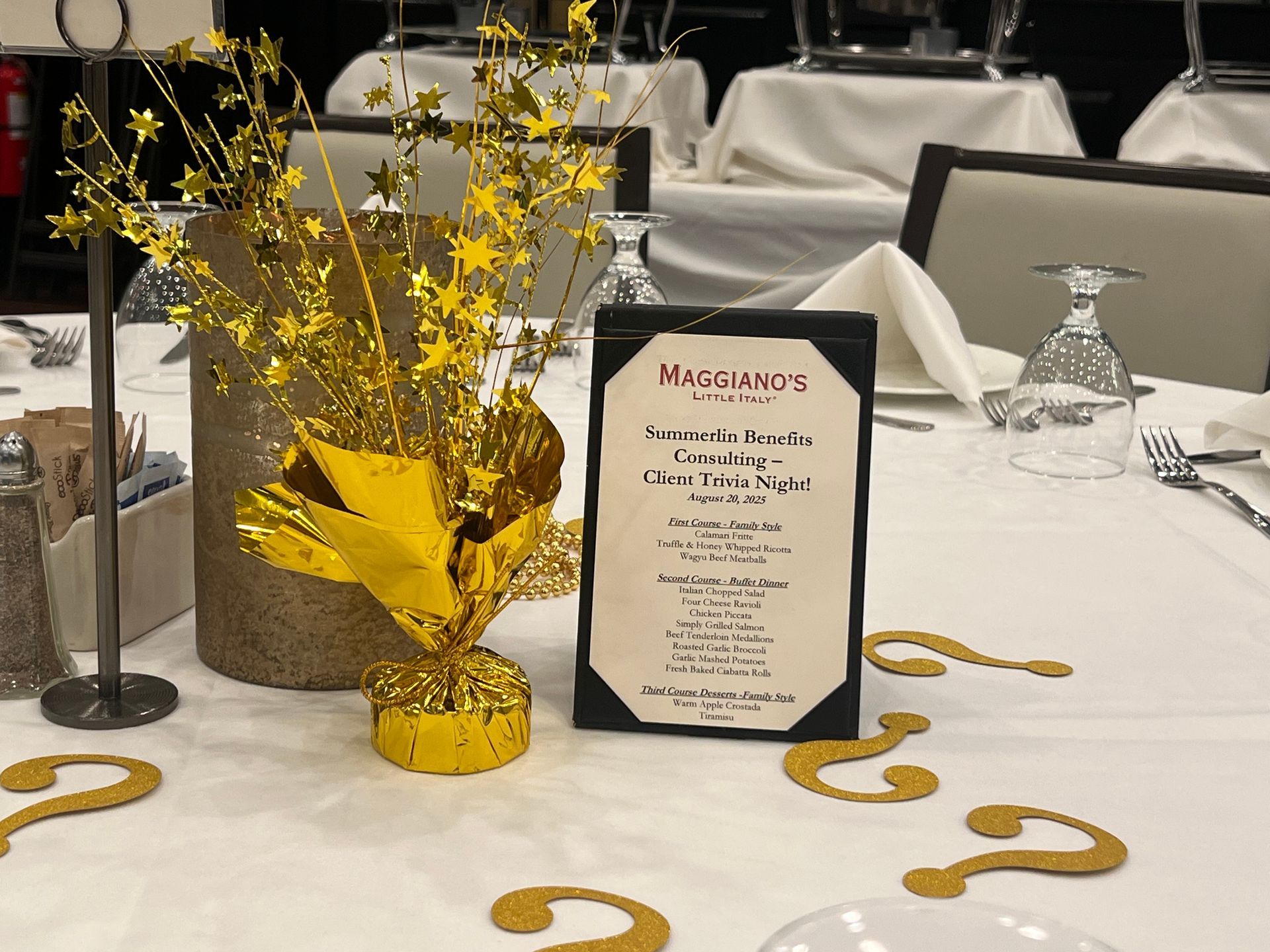 Table setting with gold stars, menu, and question mark confetti.