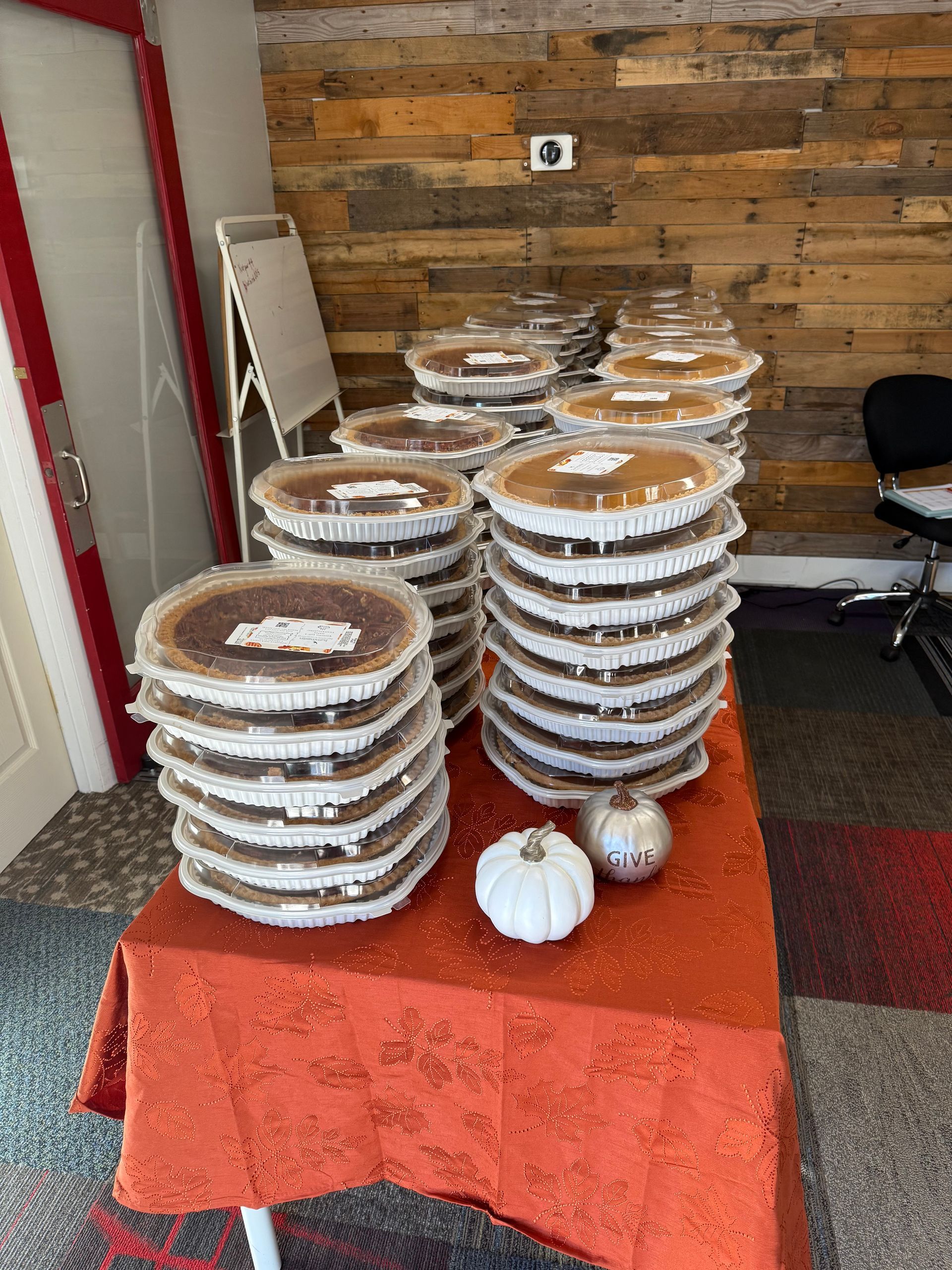 Stacks of frosted desserts on an orange tablecloth in a rustic room, with a mirror and chair nearby