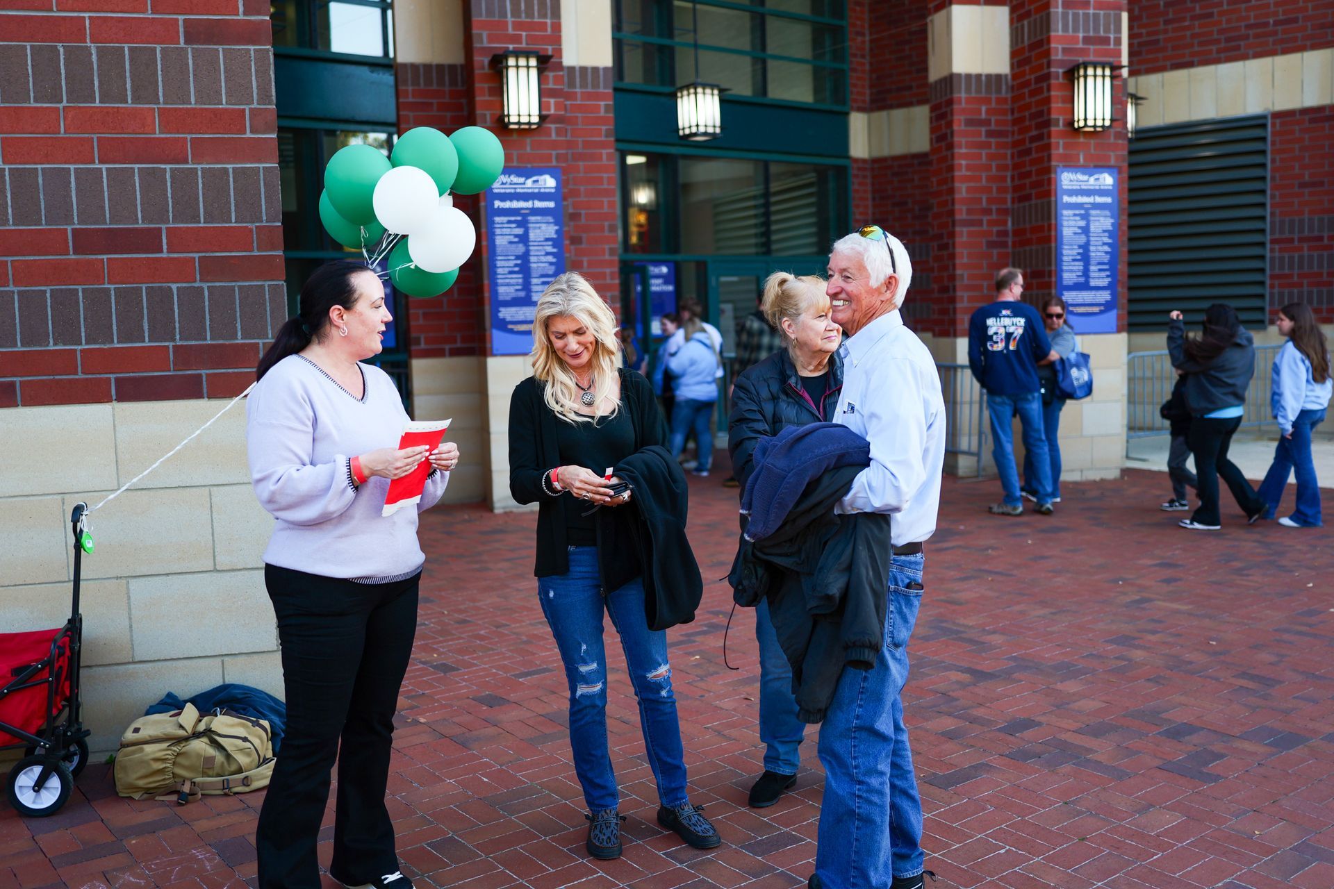 A woman is talking to a group of people outside of a building