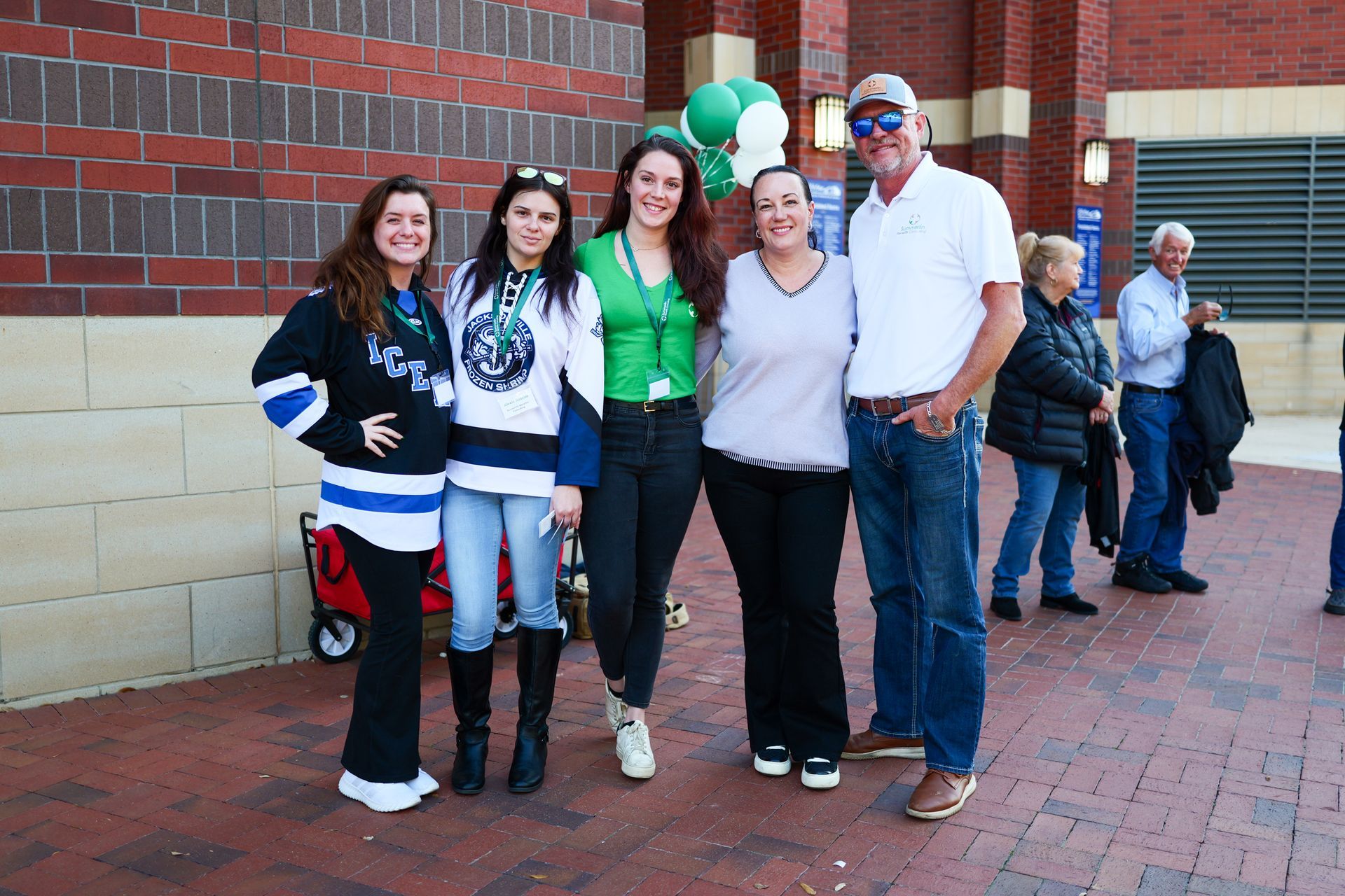 A group of people posing for a picture in front of a brick building