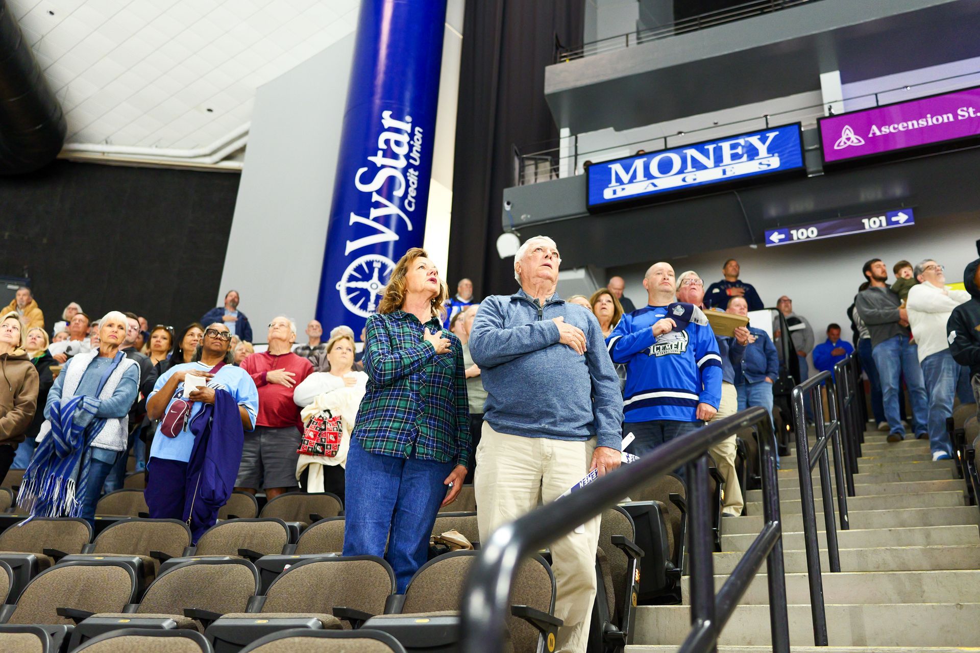A group of people standing in front of a sign that says money