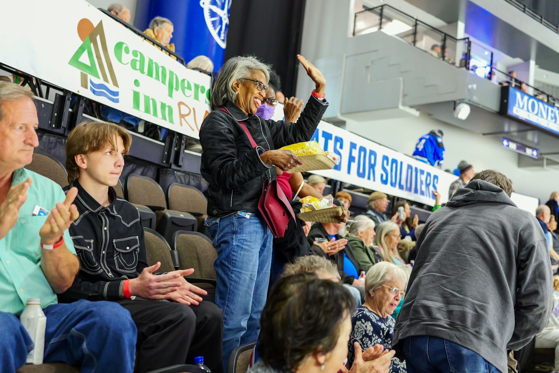 A group of people are sitting in a stadium watching a game.