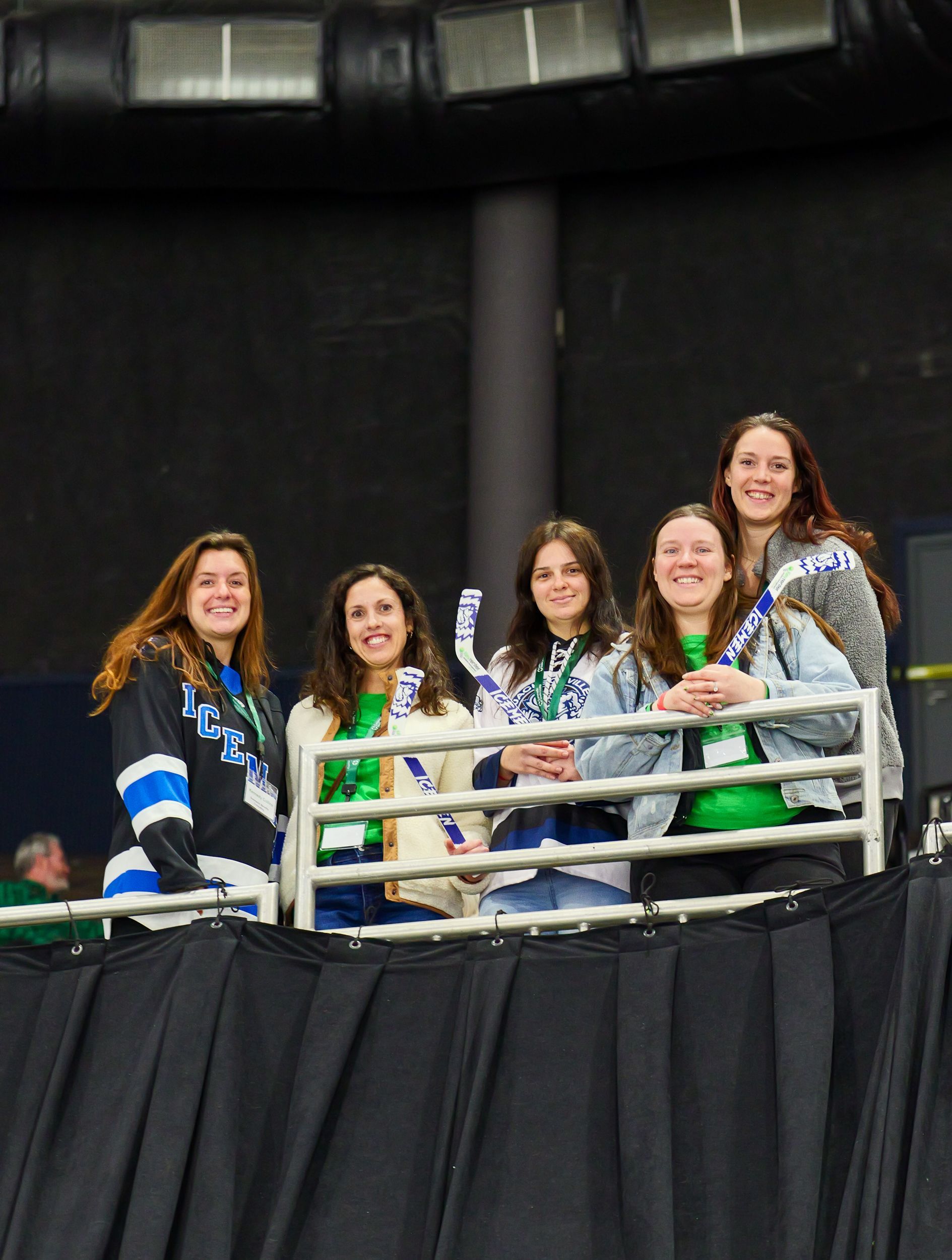 A group of women are standing next to each other on a balcony.