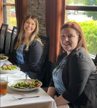 Two women are sitting at a table with plates of food