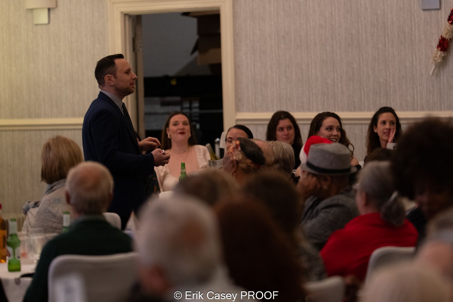 A man is giving a speech to a crowd of people at a dinner party.