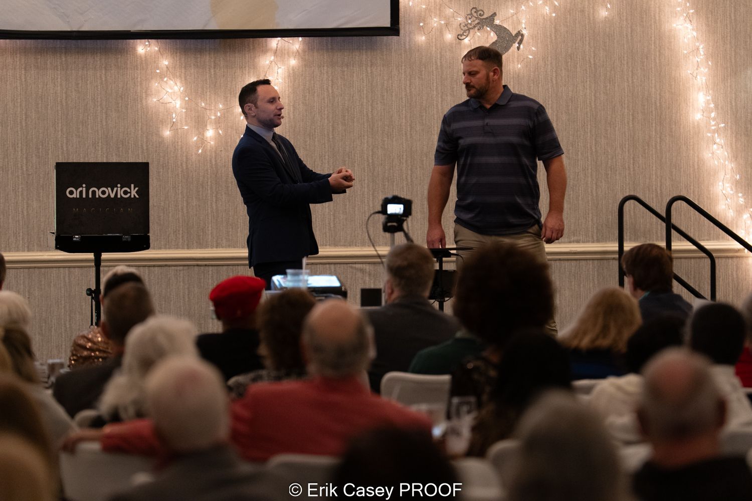 Two men are standing in front of a crowd of people.