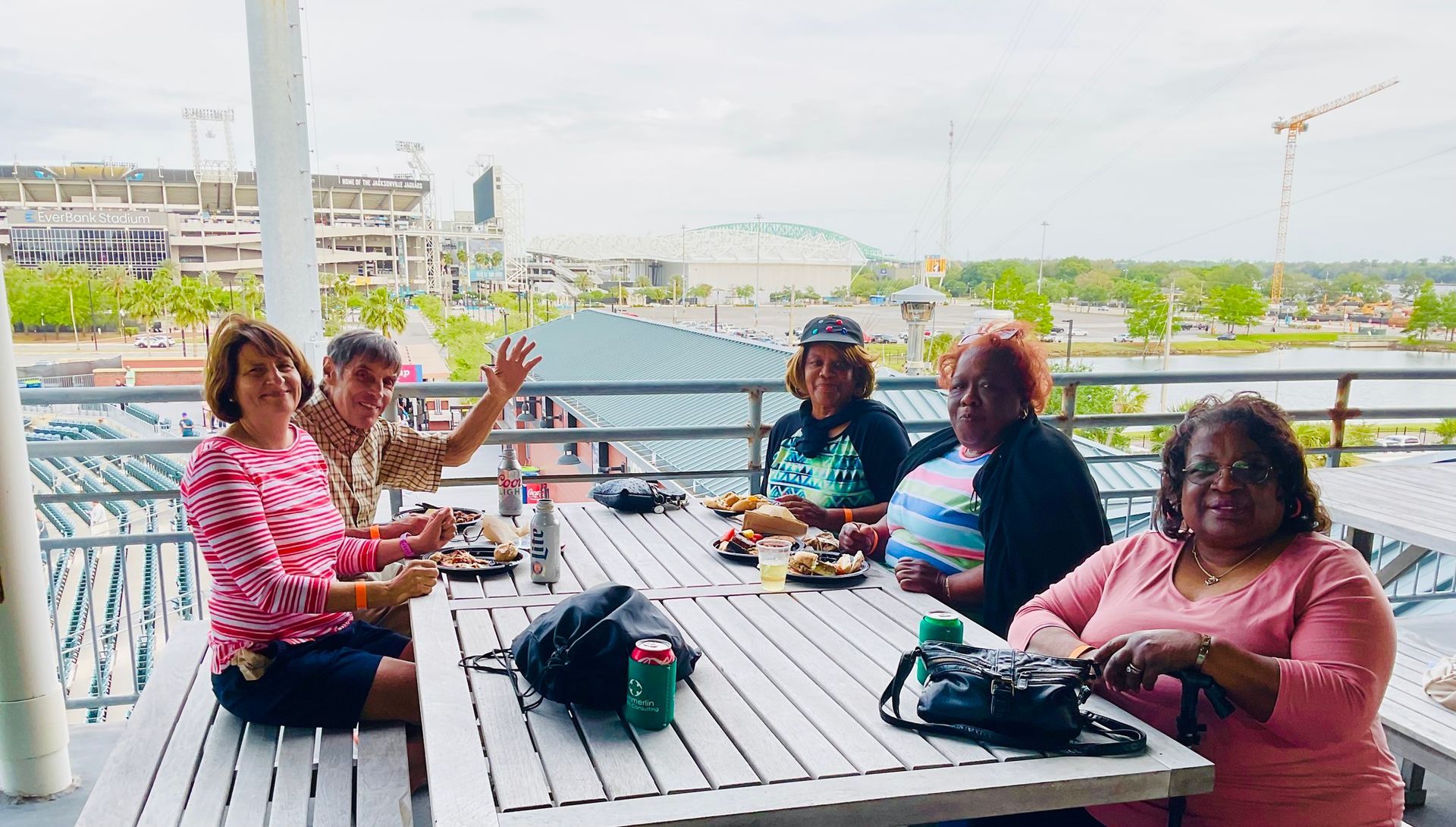 A group of people are sitting at a picnic table on a balcony.