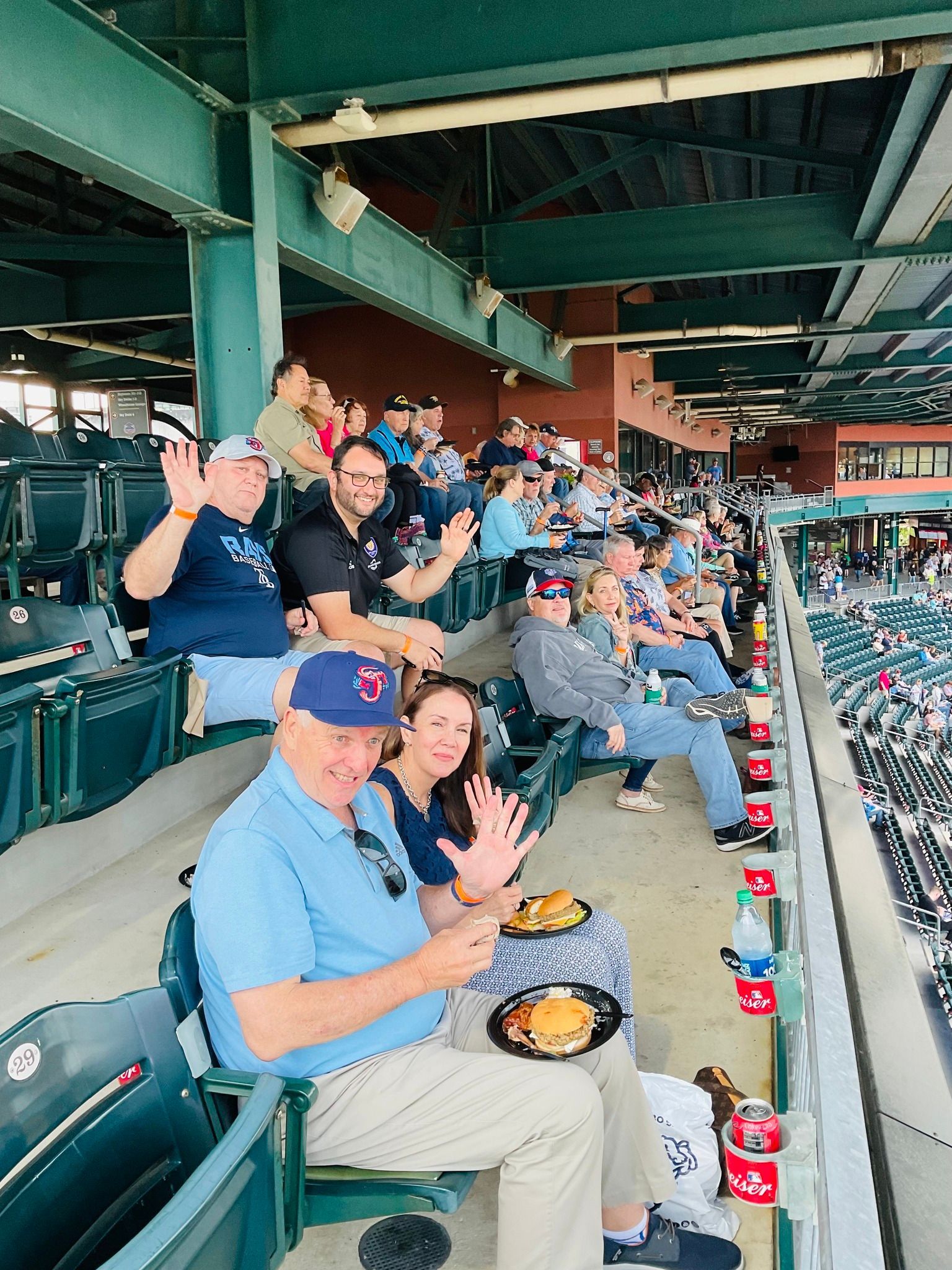 A group of people are sitting in a stadium eating food.