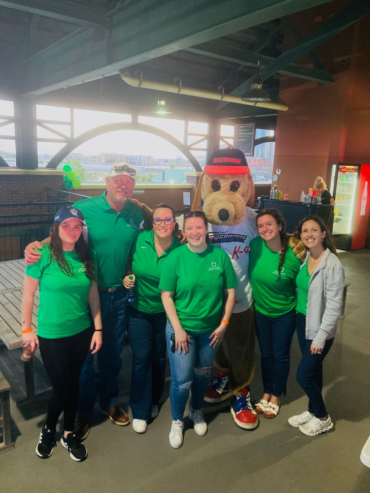 A group of people are posing for a picture with a mascot.