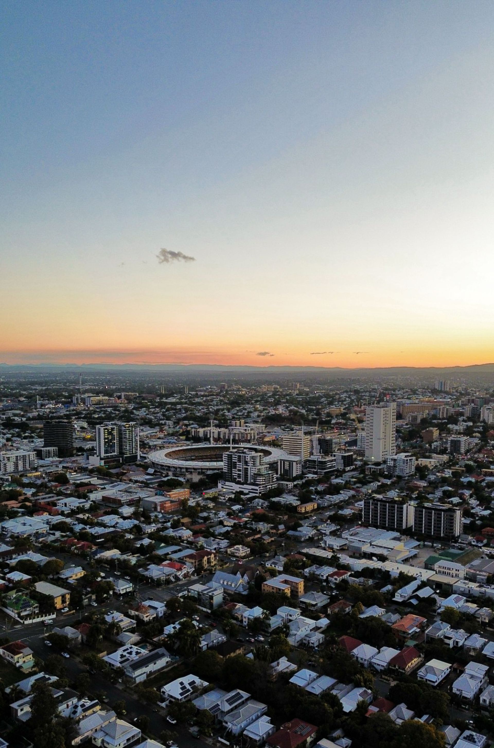 Sunset aerial view of coastal skyscrapers beside a beach and ocean