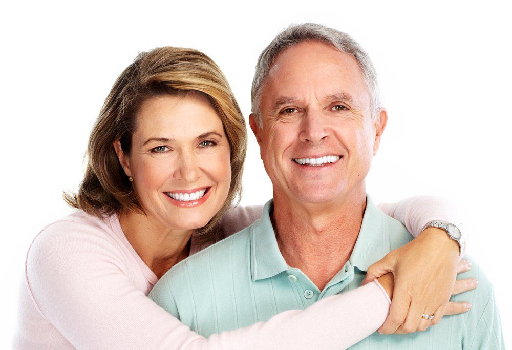 Un homme et une femme s'embrassent et sourient à la caméra.