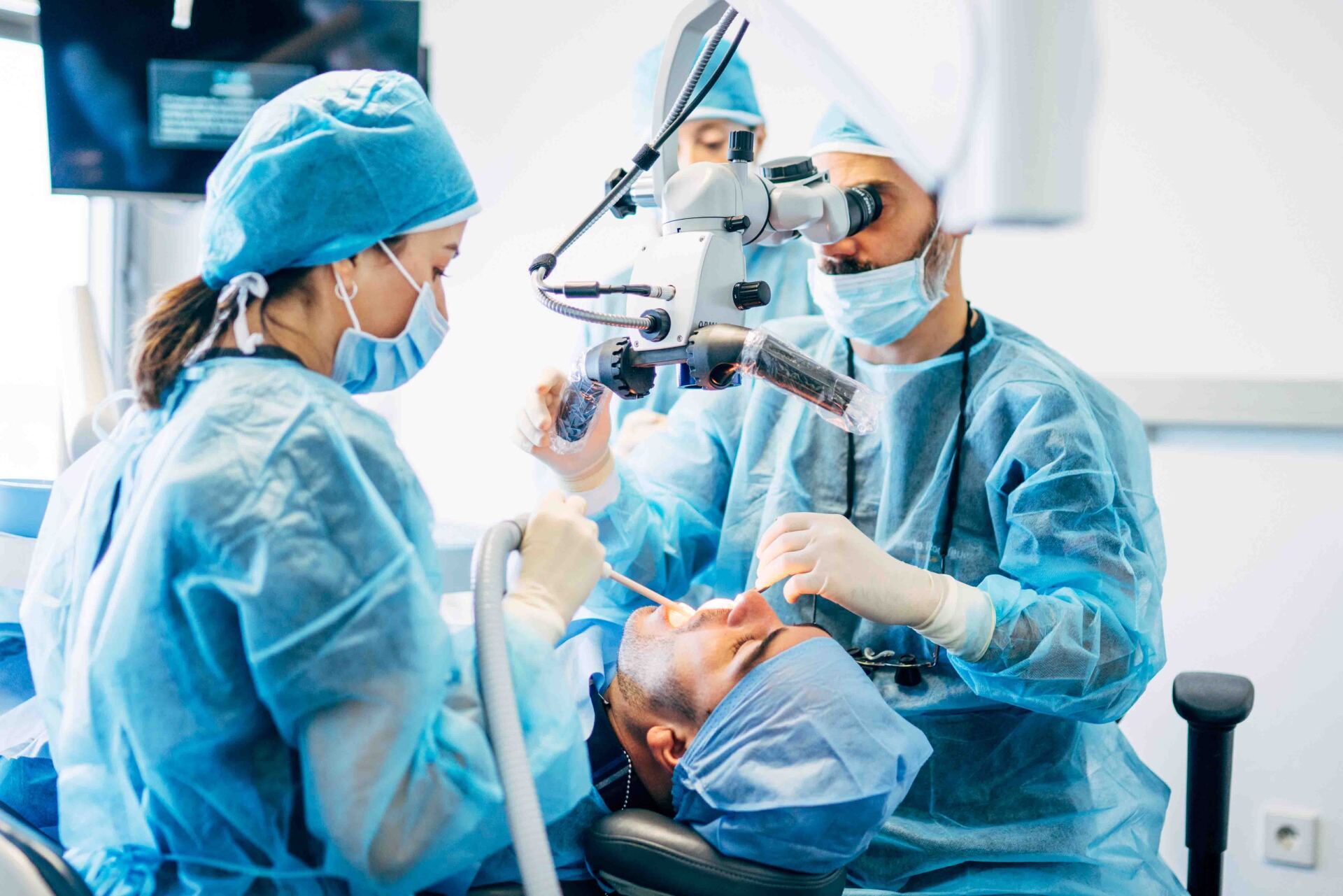 Un groupe de dentistes travaille sur les dents d'un patient dans un cabinet dentaire.